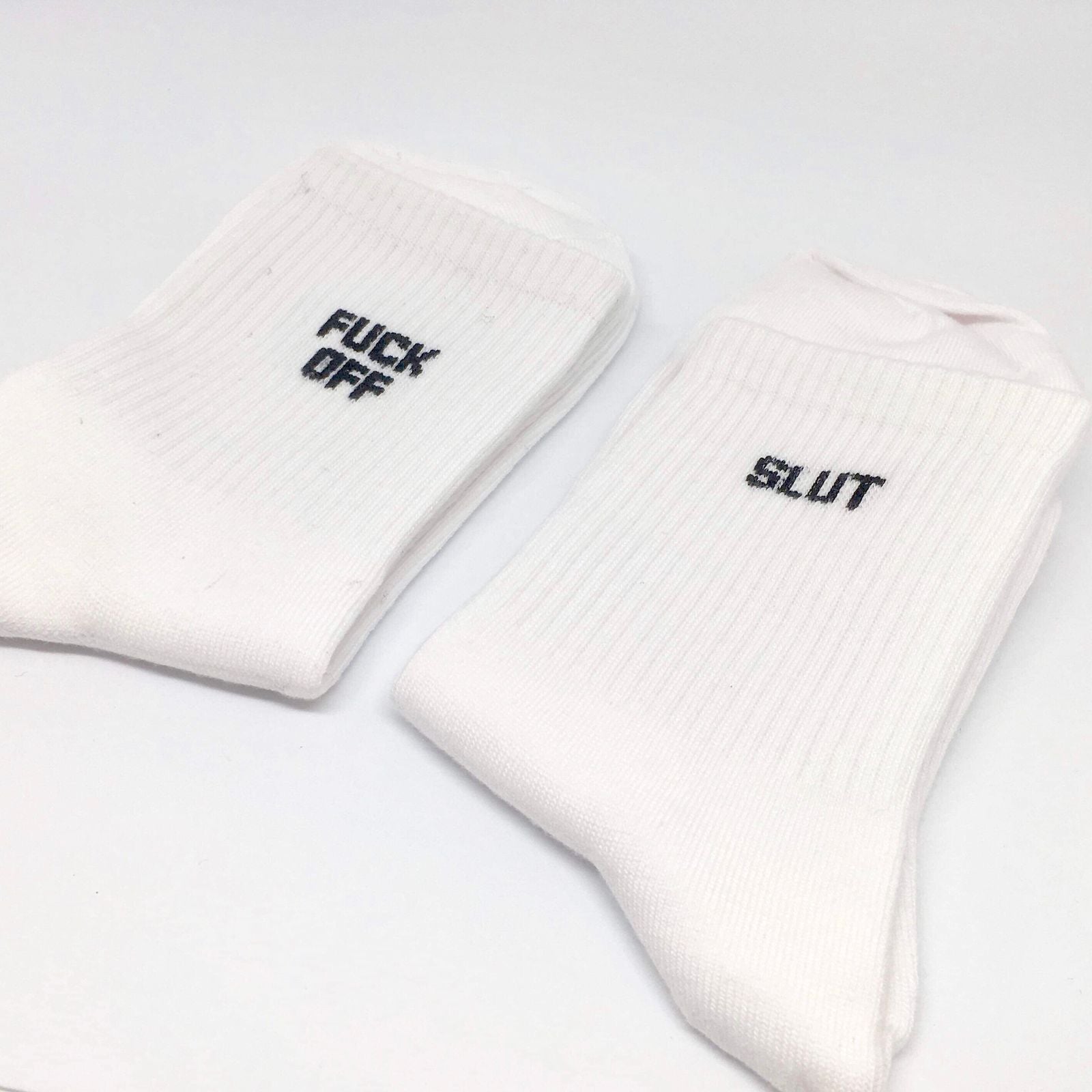 A pair of colorful cotton socks featuring playful swear words, showcasing a fun and quirky design suitable for all occasions.