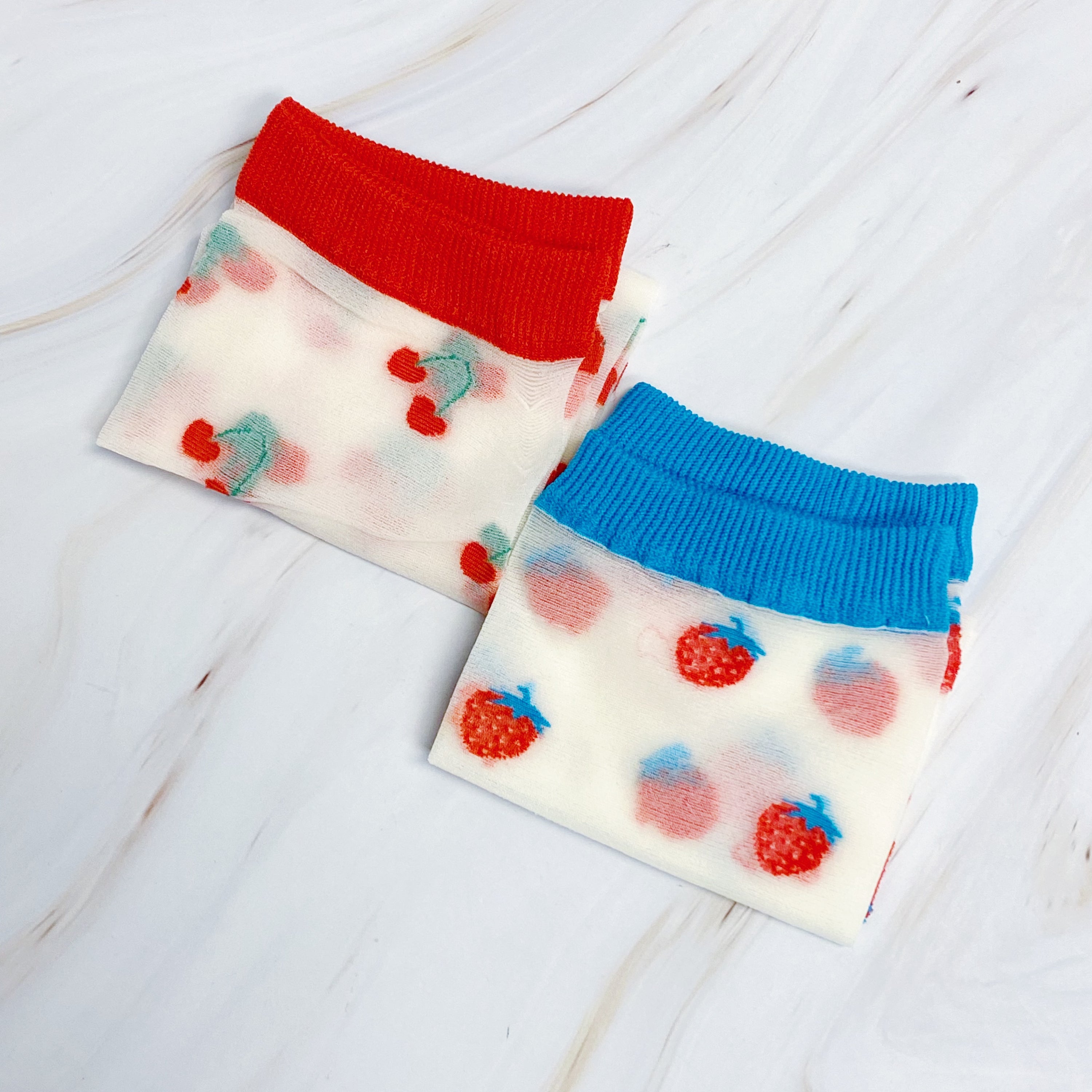 Set of two pairs of sheer socks featuring colorful fruit designs, lightweight and stylish.