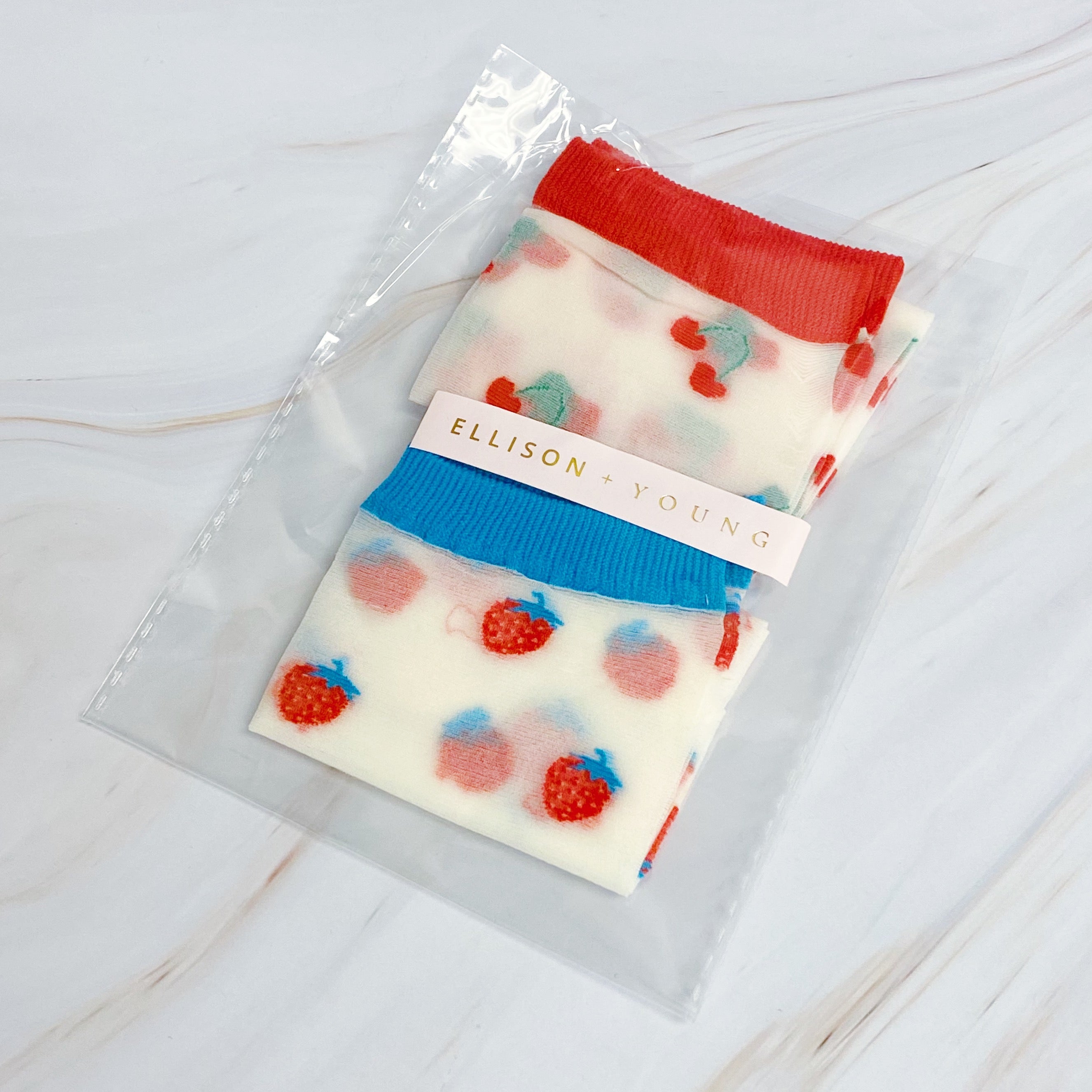 Set of two pairs of sheer socks featuring colorful fruit designs, lightweight and stylish.