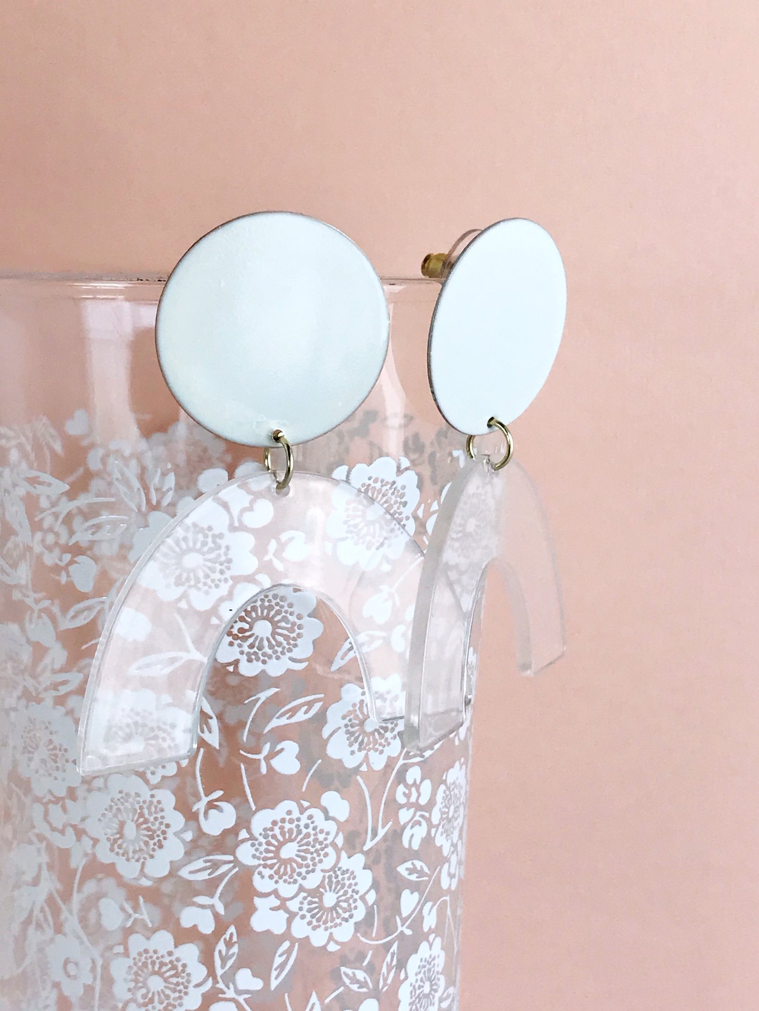 Sydney earrings featuring ivory painted brass discs and clear faux tortoise shell arches, lightweight and stylish.