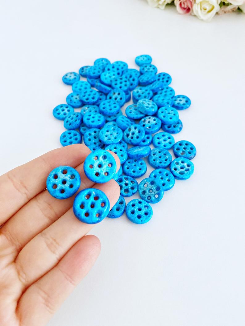 A collection of Syriac Evil Eye Beads featuring 7 holes, ideal for jewelry making, showcasing vibrant colors and intricate designs.