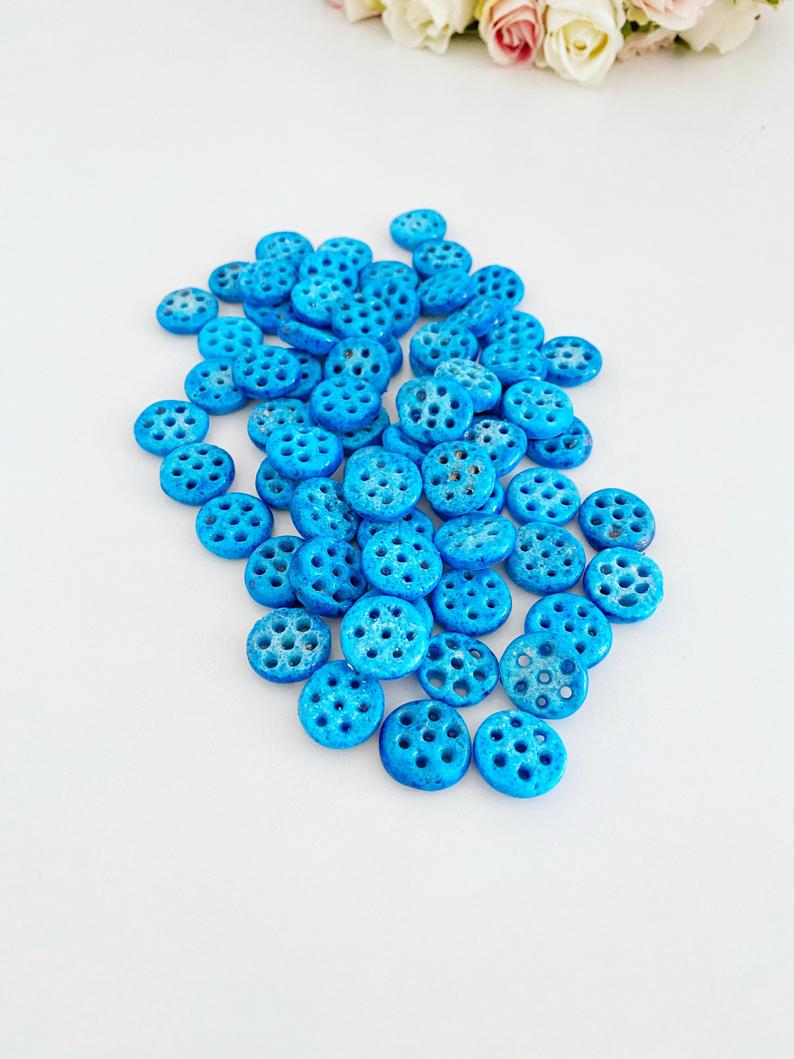 A collection of Syriac Evil Eye Beads featuring 7 holes, ideal for jewelry making, showcasing vibrant colors and intricate designs.