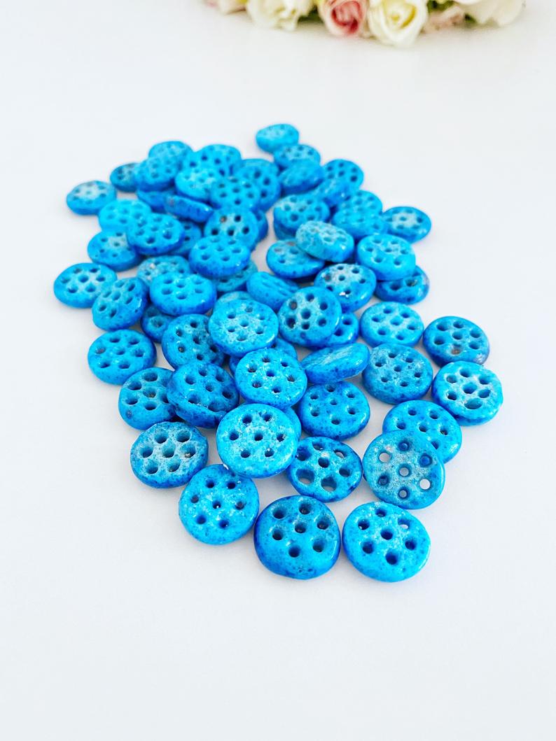 A collection of Syriac Evil Eye Beads featuring 7 holes, ideal for jewelry making, showcasing vibrant colors and intricate designs.