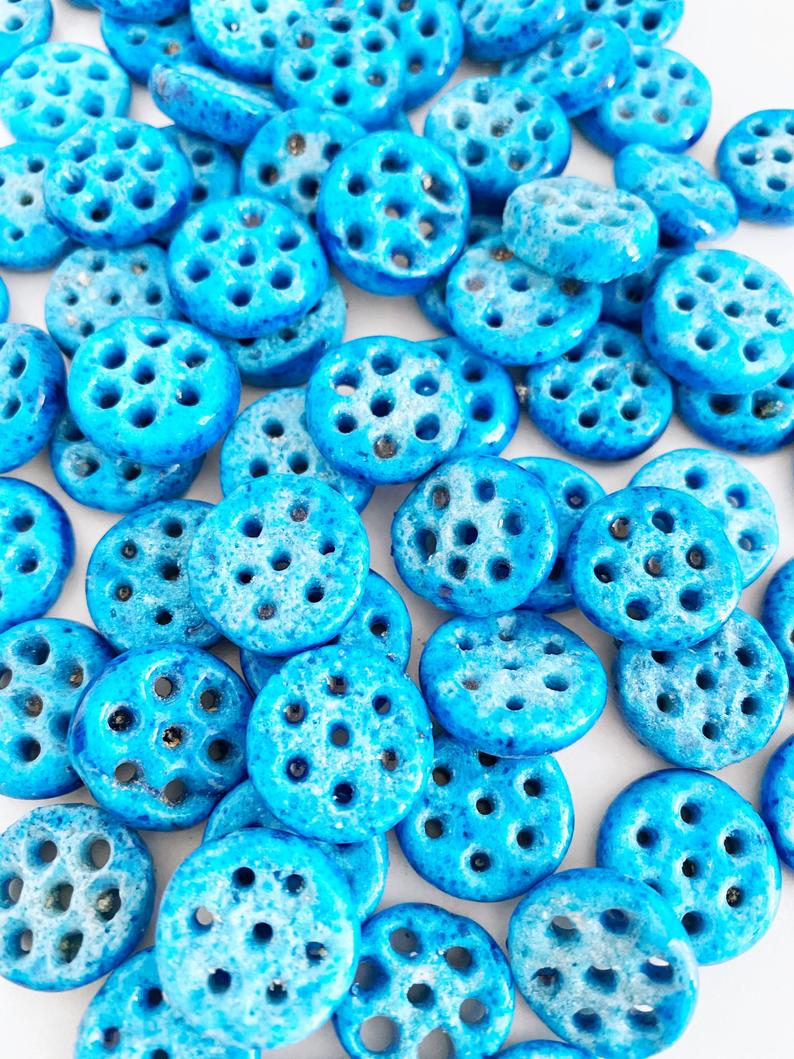 A collection of Syriac Evil Eye Beads featuring 7 holes, ideal for jewelry making, showcasing vibrant colors and intricate designs.