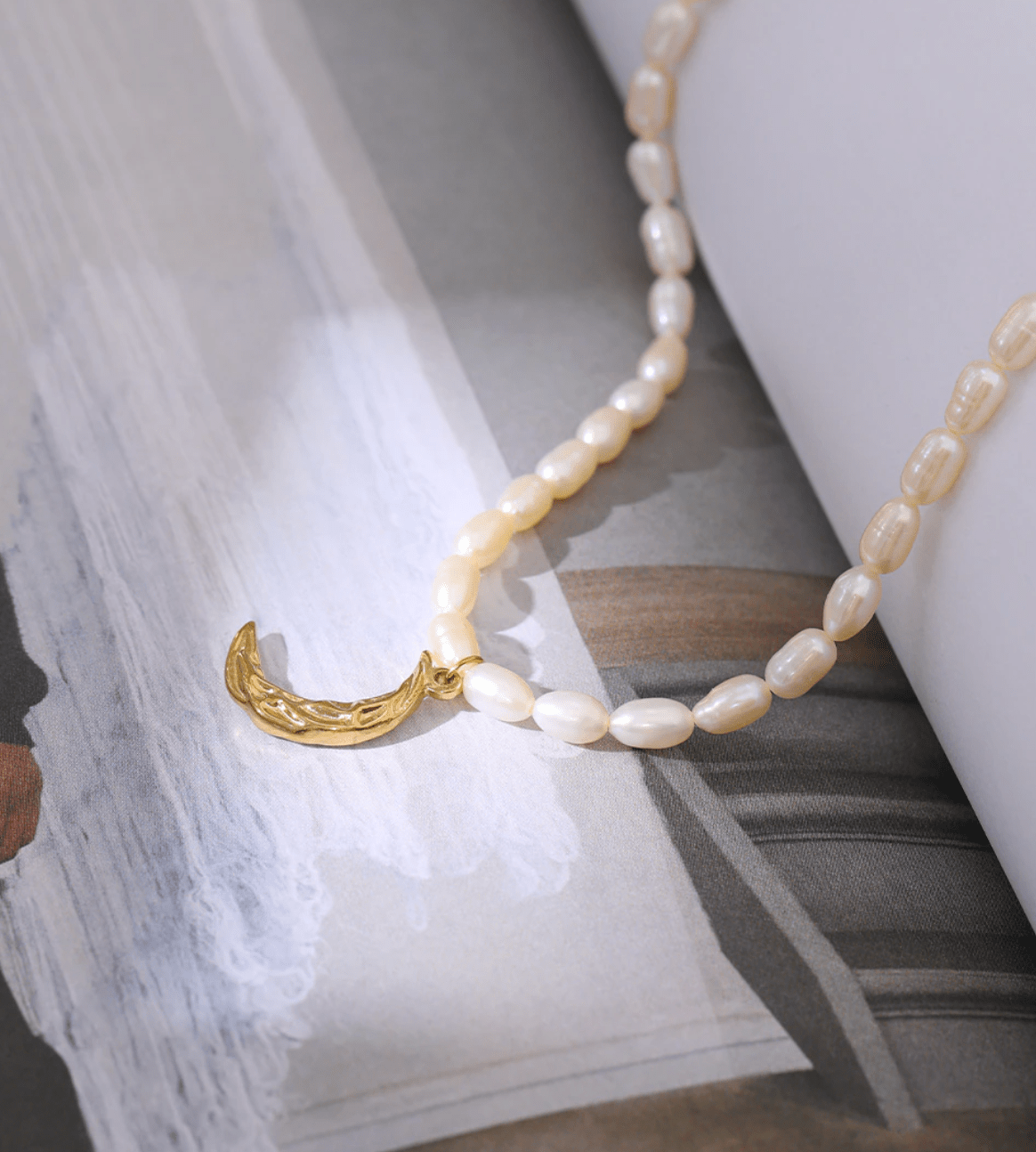 Taletha Crescent Gold Moon Natural Pearl Charm Necklace featuring a pearl coin and gold chain, symbolizing elegance and durability.