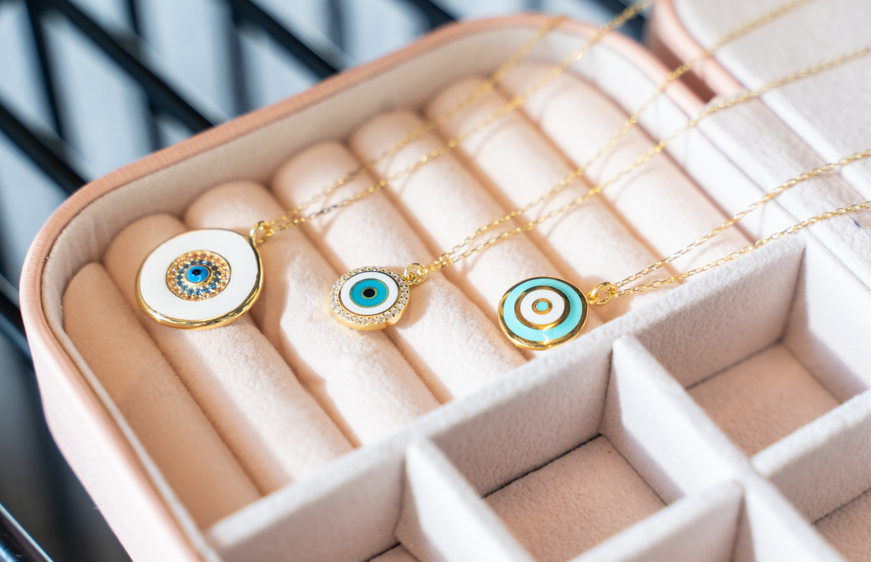 TARA Necklace featuring a round evil eye pendant with sparkling cubic zirconias and yellow gold plating on a delicate chain.