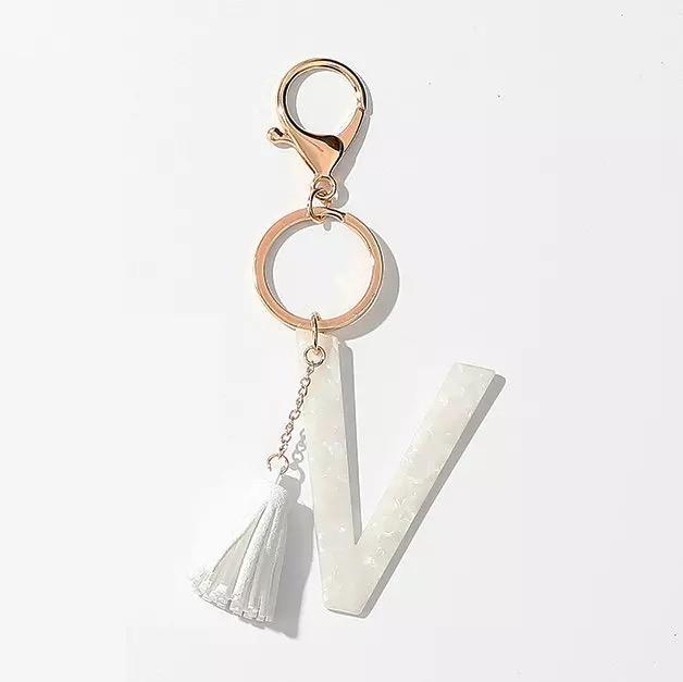 Stylish white key chain featuring a tassel and personalized initial, perfect for organizing keys.