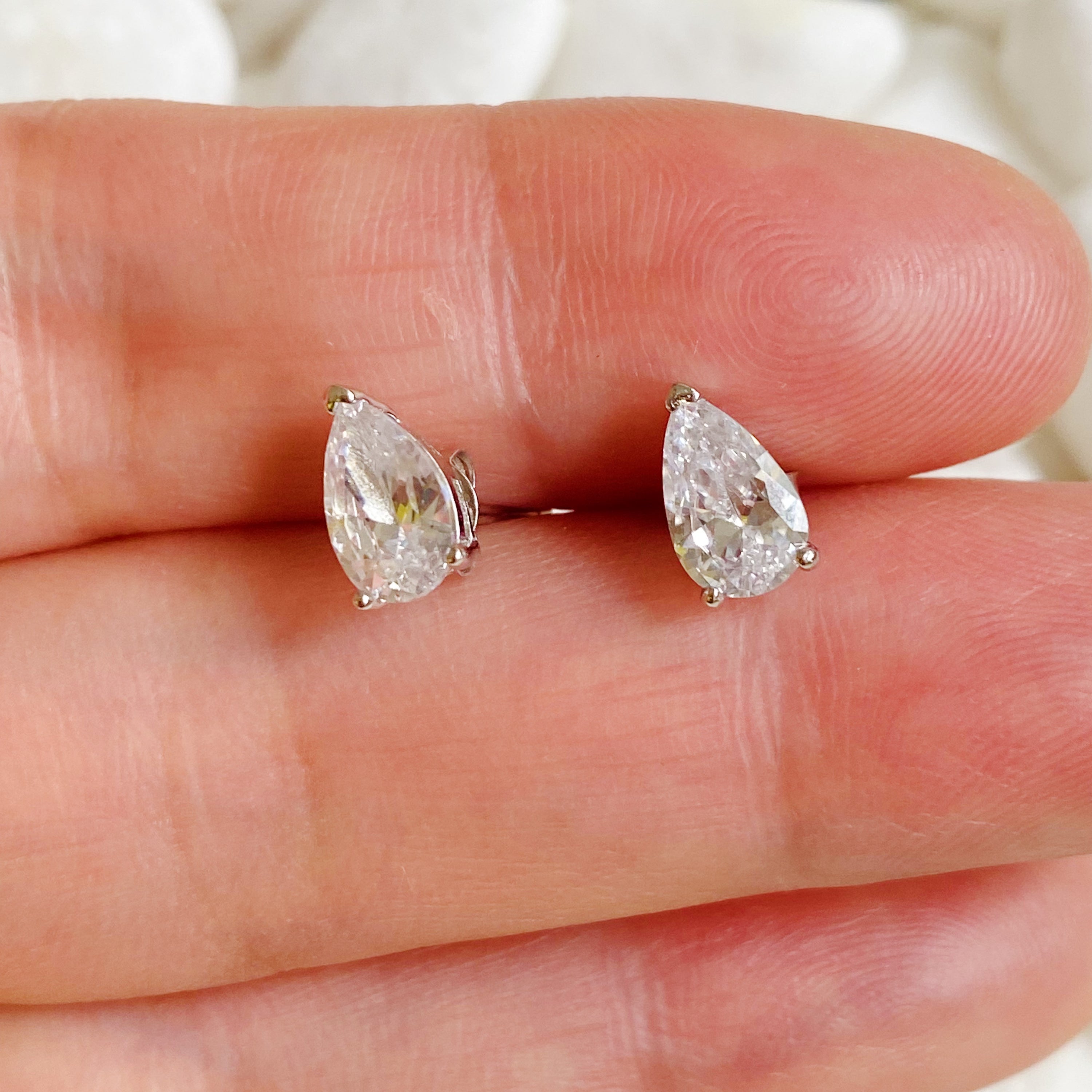 Elegant teardrop sterling silver stud earrings with sparkling Cubic Zirconia stones, showcasing their beautiful design and craftsmanship.