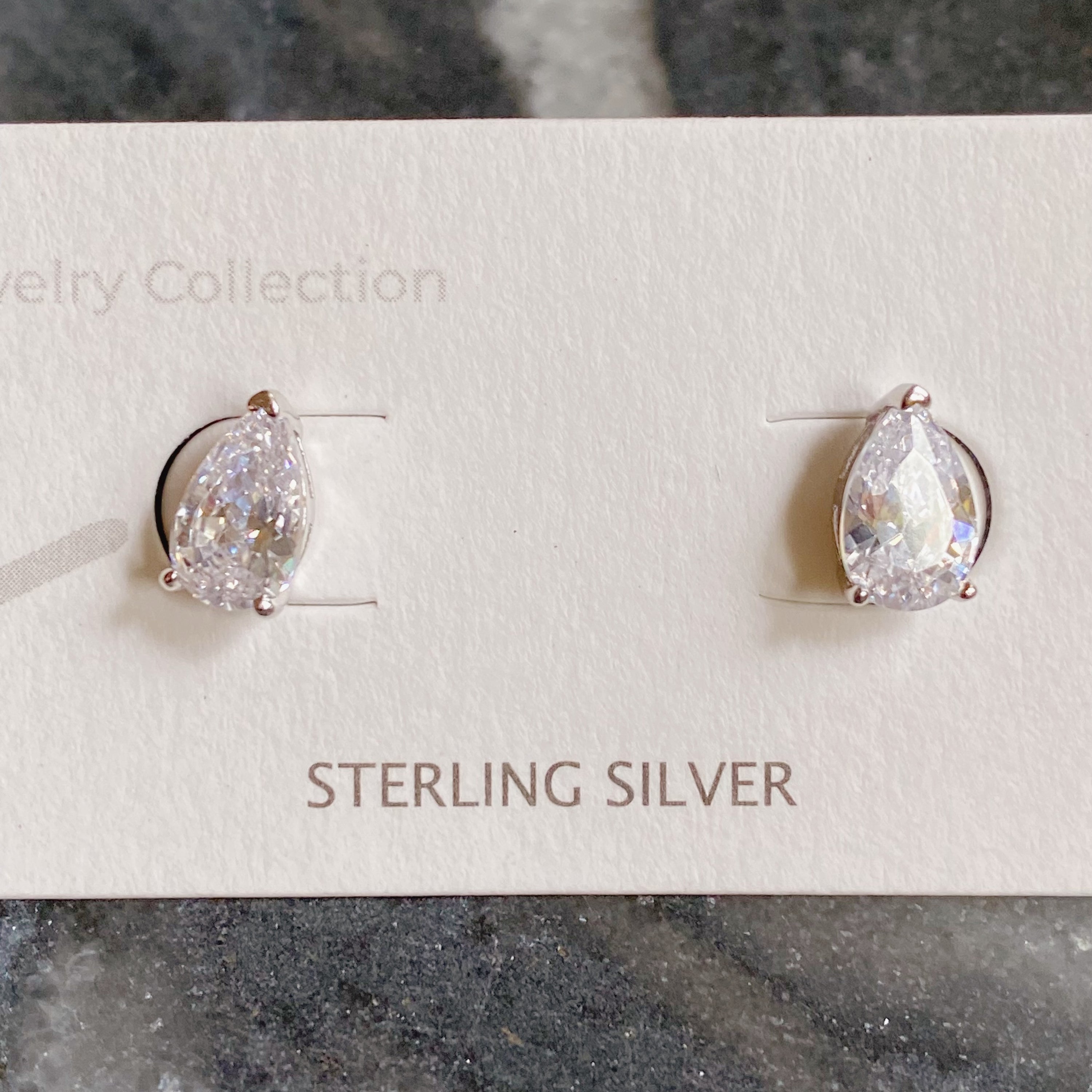 Elegant teardrop sterling silver stud earrings with sparkling Cubic Zirconia stones, showcasing their beautiful design and craftsmanship.