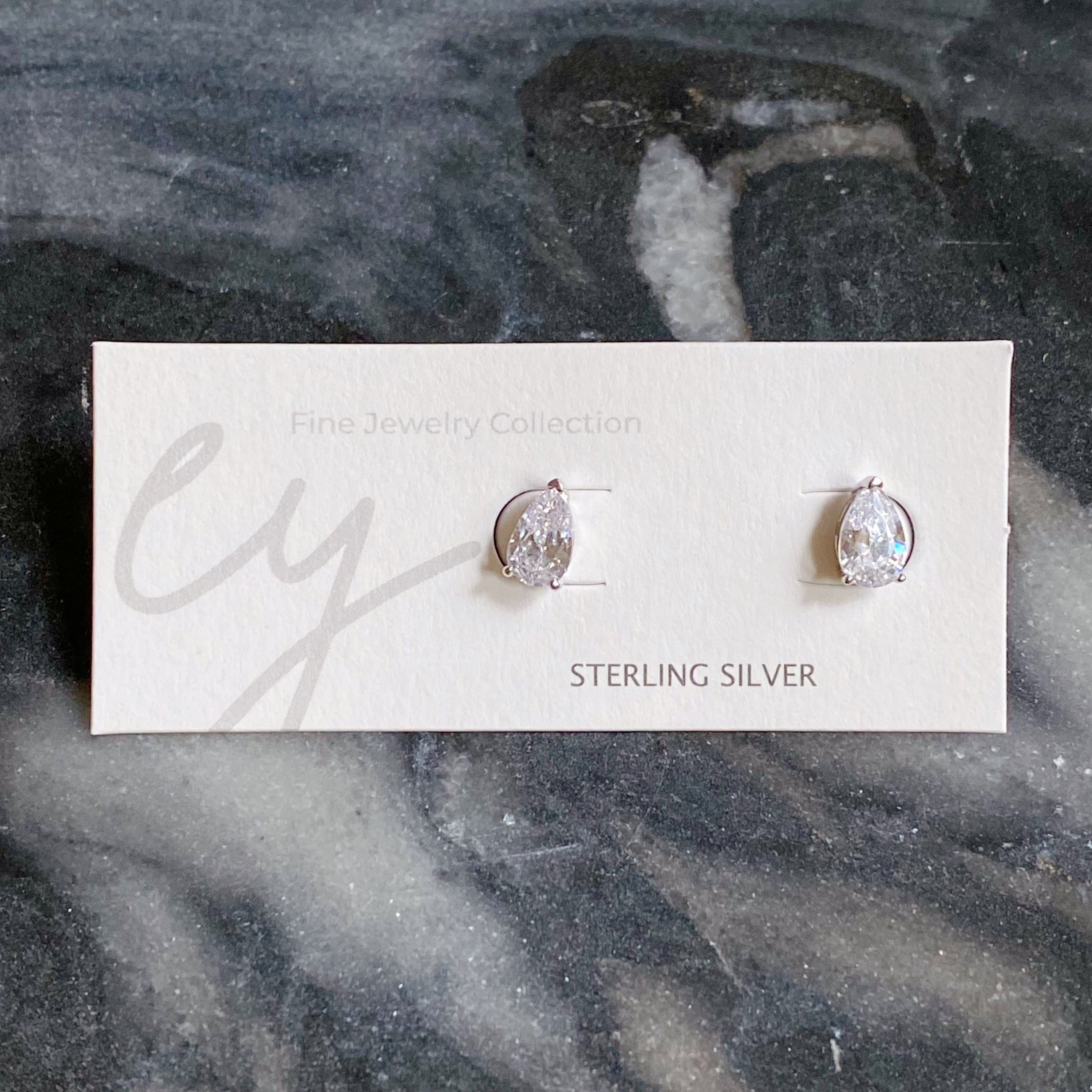 Elegant teardrop sterling silver stud earrings with sparkling Cubic Zirconia stones, showcasing their beautiful design and craftsmanship.