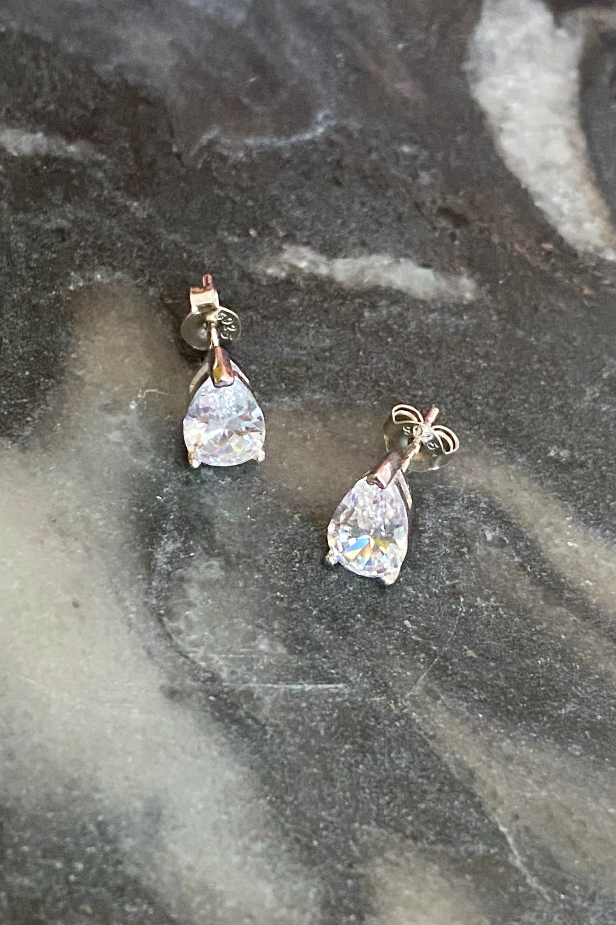 Elegant teardrop sterling silver stud earrings with sparkling Cubic Zirconia stones, showcasing their beautiful design and craftsmanship.