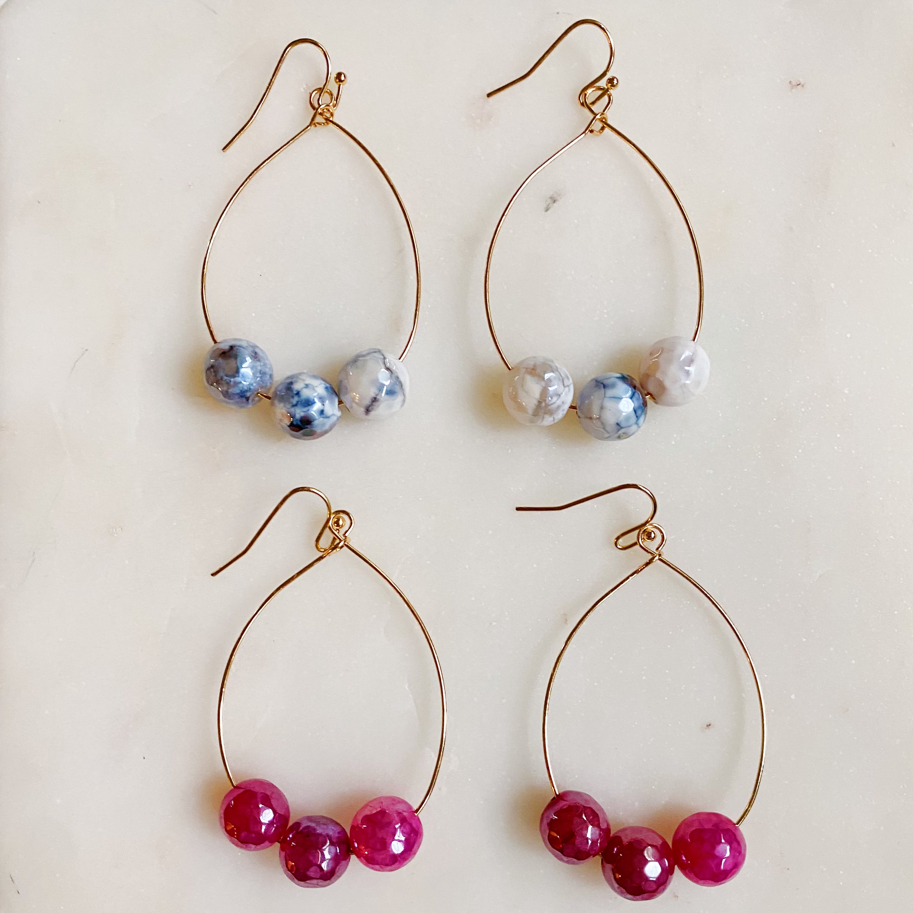 Elegant teardrop wire earrings featuring dimensionally cut glass beads and gold plated alloy metal.