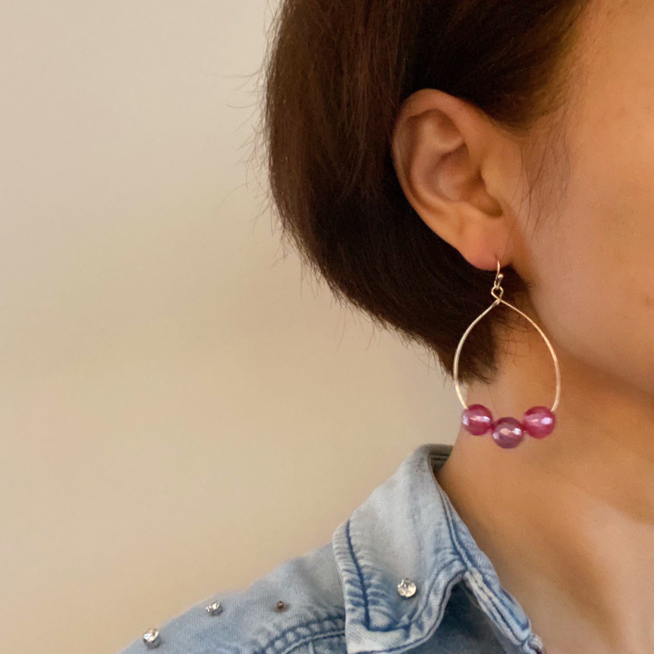 Elegant teardrop wire earrings featuring dimensionally cut glass beads and gold plated alloy metal.