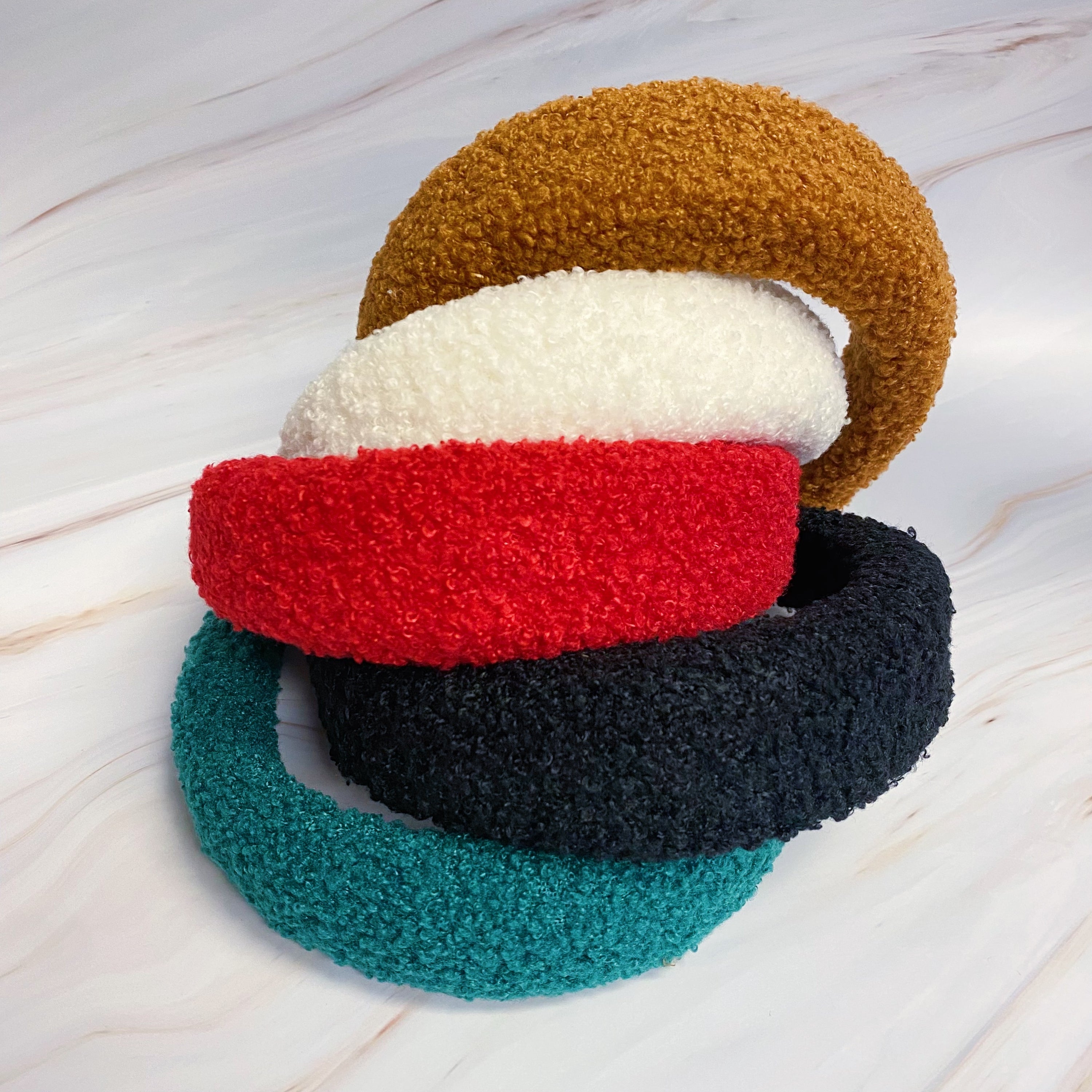 A stylish Teddy Cozy Headband made from soft, fuzzy materials, perfect for keeping hair in place while adding a cute touch to any outfit.