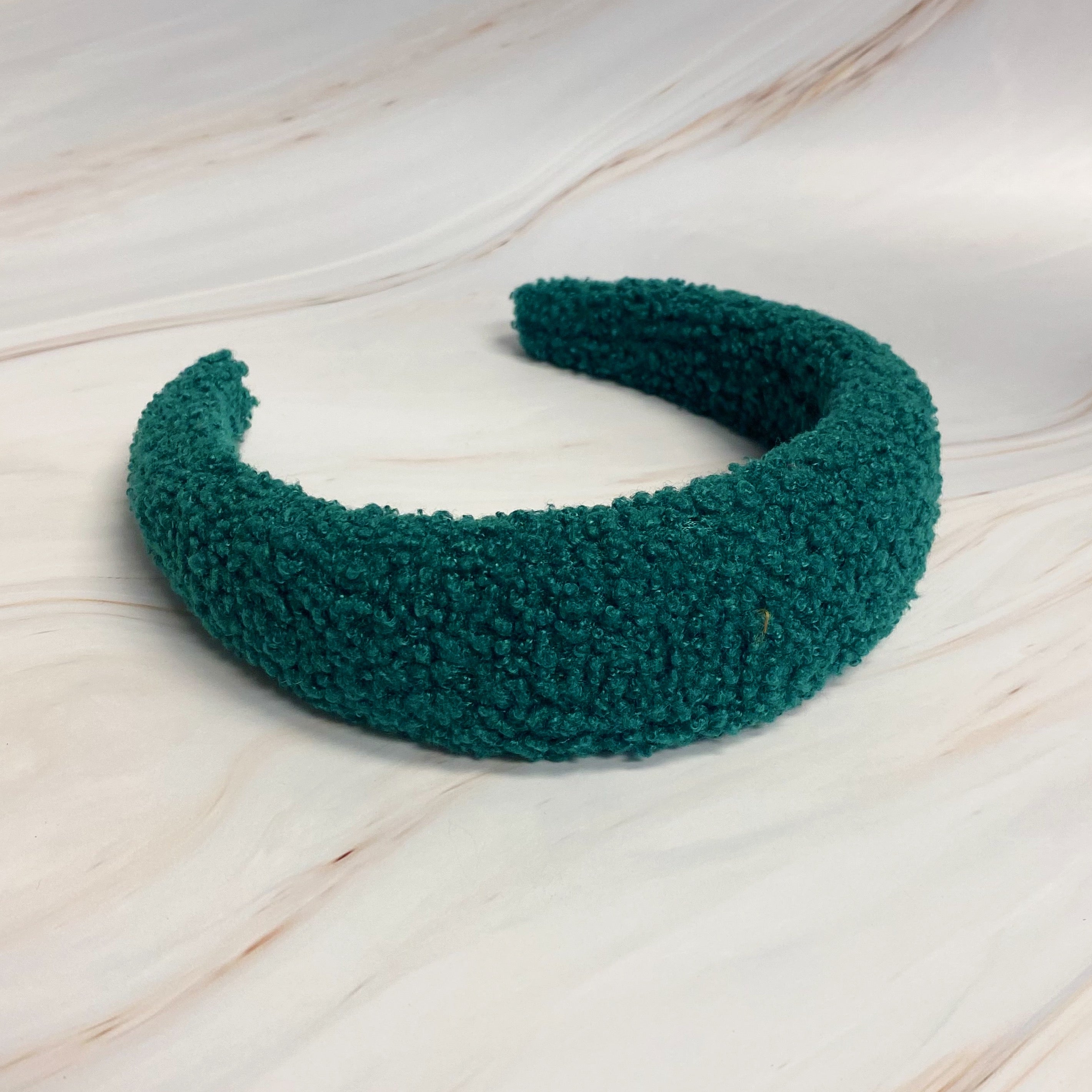 A stylish Teddy Cozy Headband made from soft, fuzzy materials, perfect for keeping hair in place while adding a cute touch to any outfit.