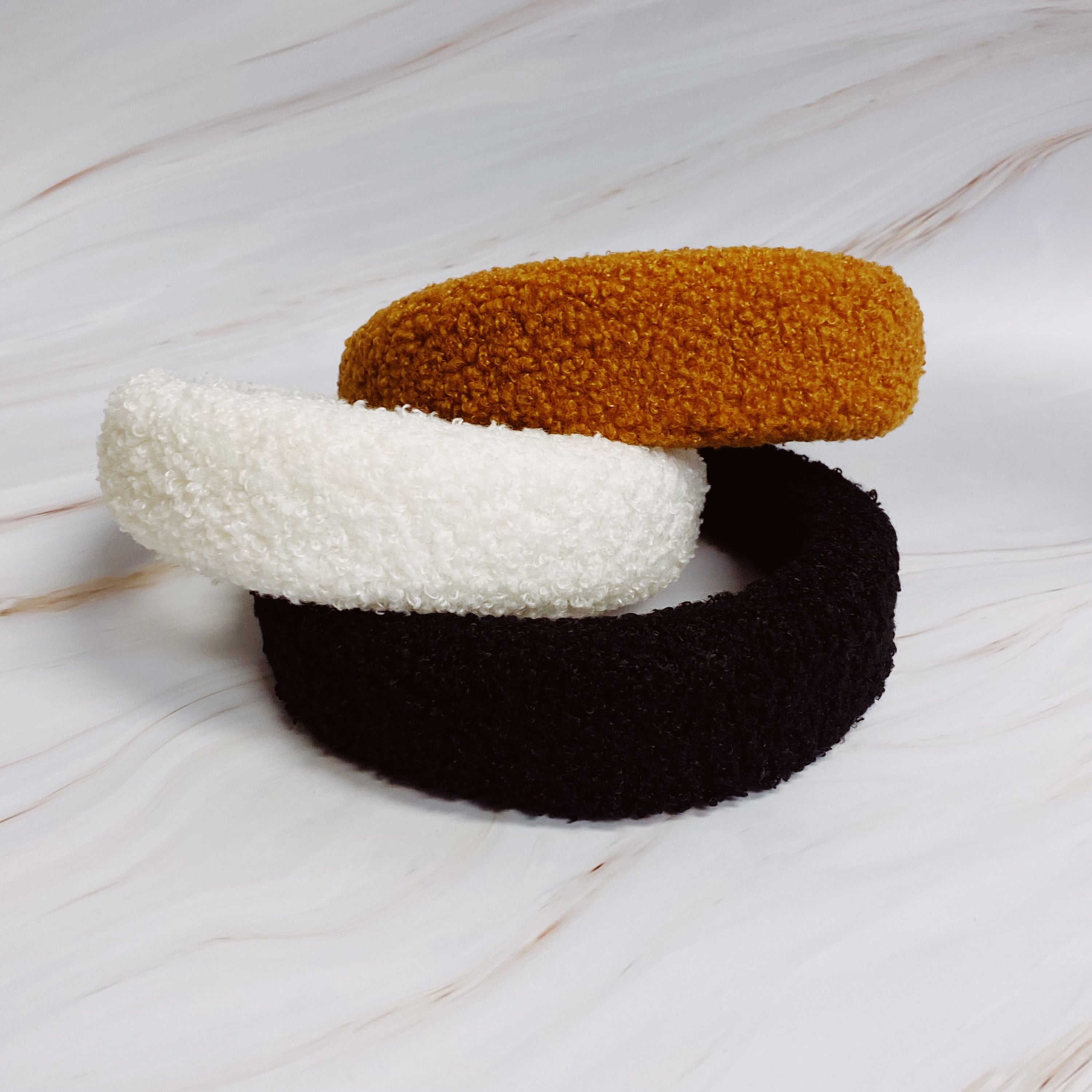 A stylish Teddy Cozy Headband made from soft, fuzzy materials, perfect for keeping hair in place while adding a cute touch to any outfit.