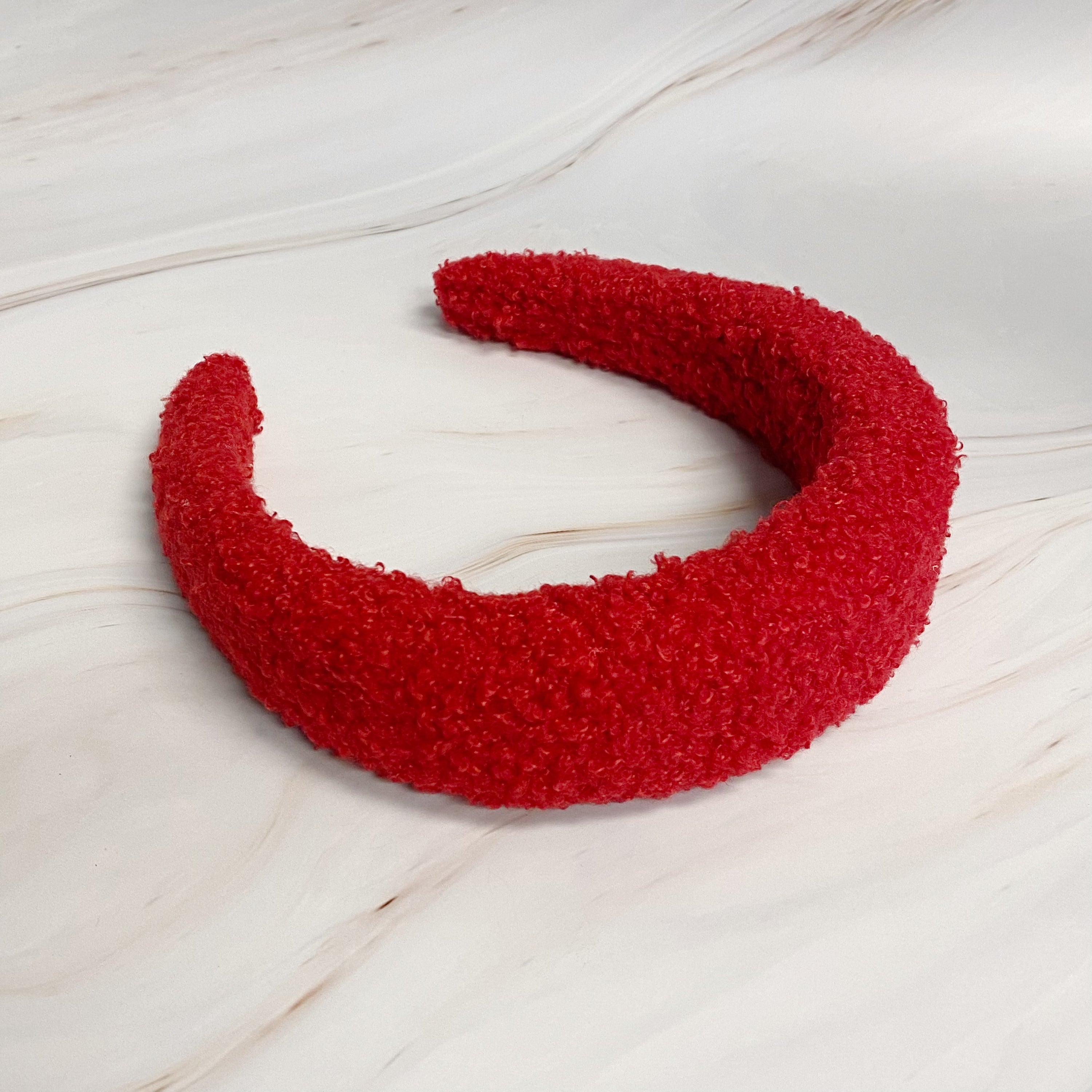 A stylish Teddy Cozy Headband made from soft, fuzzy materials, perfect for keeping hair in place while adding a cute touch to any outfit.