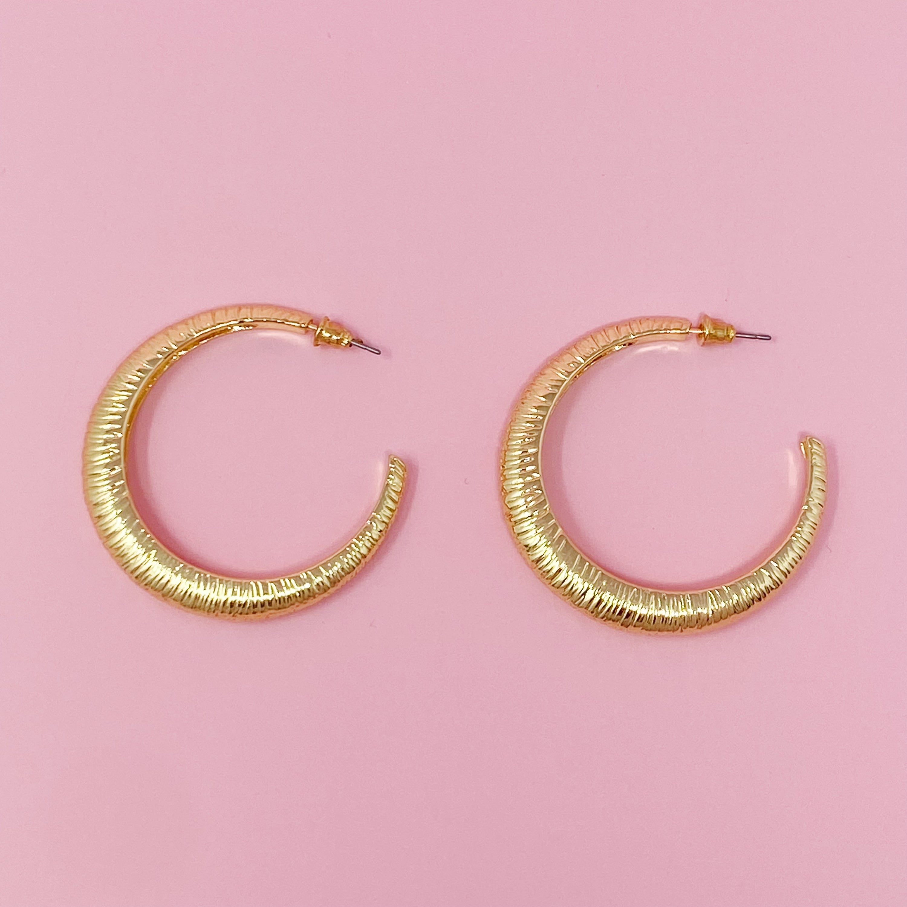 A pair of textured daily hoop earrings with a dimensional finish, perfect for everyday wear and special occasions.