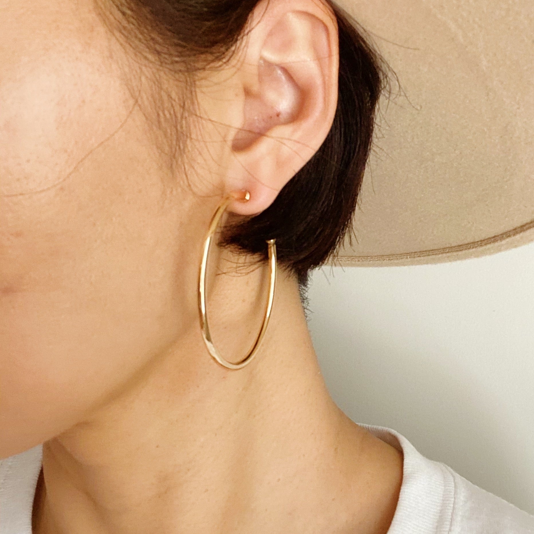 Shiny gold hoop earrings with a 2-inch diameter, lightweight and stylish, perfect for everyday wear.