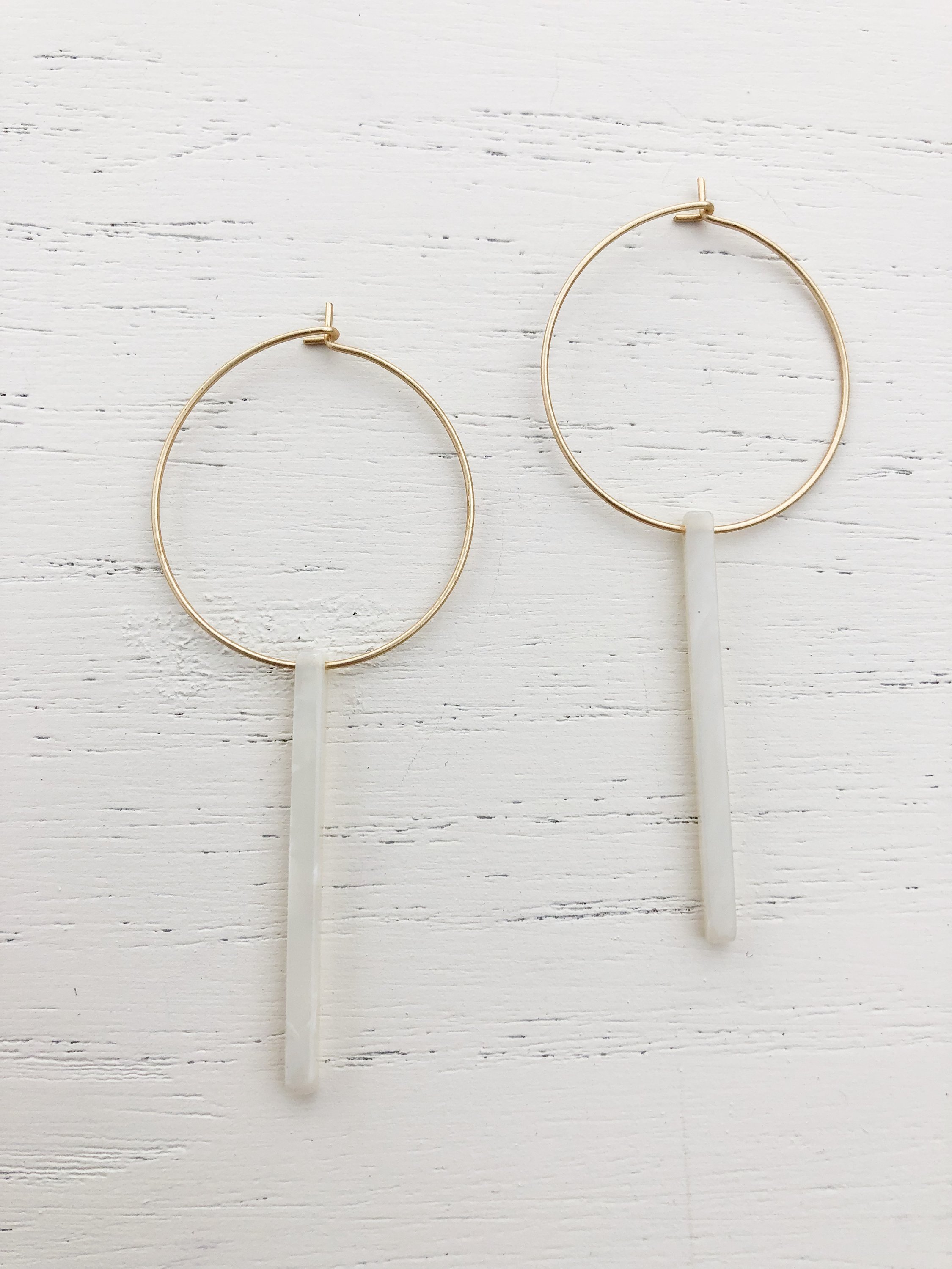 Elegant gold plated hoop earrings with white tortoise resin detail, measuring 2-5/8 inches in length.