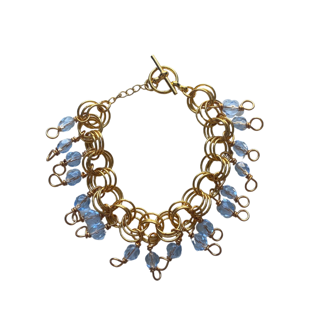 The Donna Bracelet in Ice Blue featuring Czech glass beads and a toggle clasp, elegantly displayed on a soft surface.