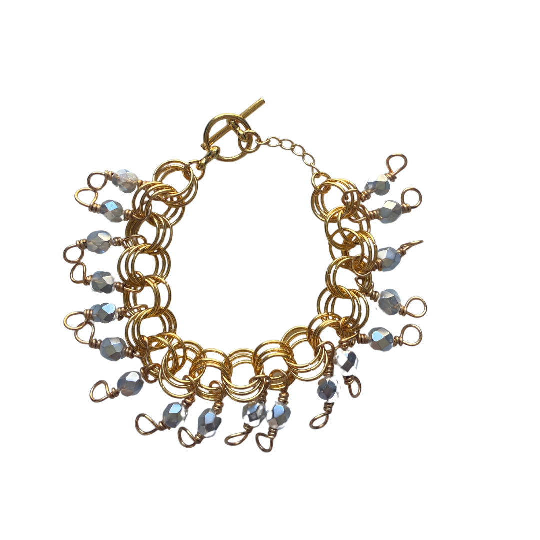 The Donna Bracelet in Metallic Silver featuring Czech fire-polished glass beads and a toggle clasp, elegantly displayed on a soft background.