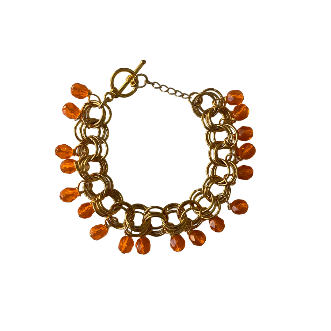 The Donna Bracelet in Orange featuring gold/silver-plated brass links and vibrant orange Czech fire-polished glass beads with a toggle clasp.