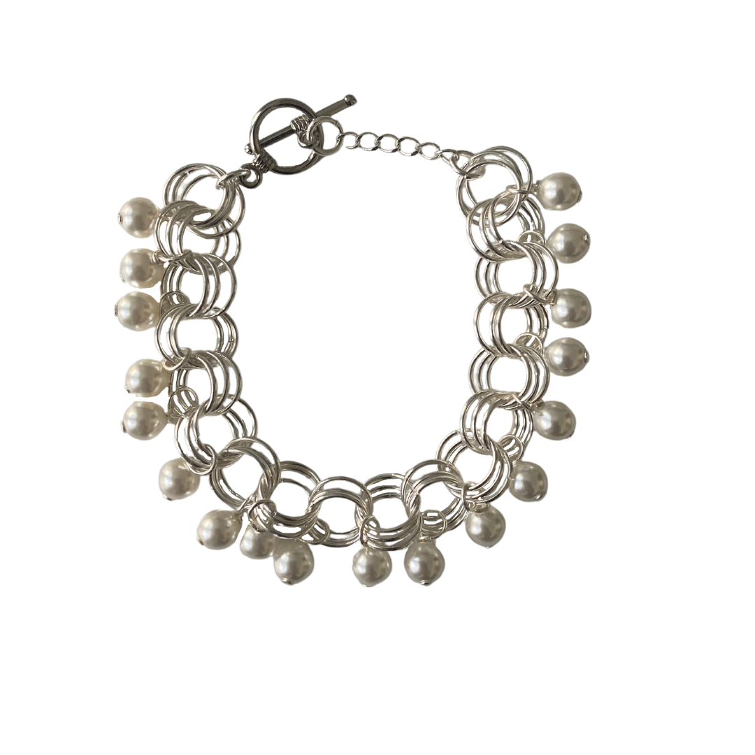 The Donna Bracelet in Pearl featuring gold/silver-plated links and pearl Czech fire-polished glass beads, elegantly designed with a toggle clasp.