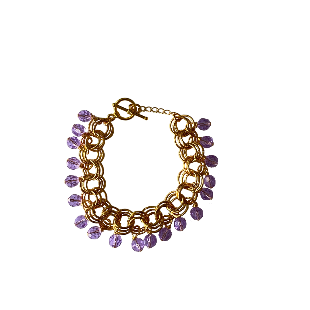 The Donna Bracelet in Violet featuring violet Czech glass beads and gold/silver-plated brass links with a toggle clasp.