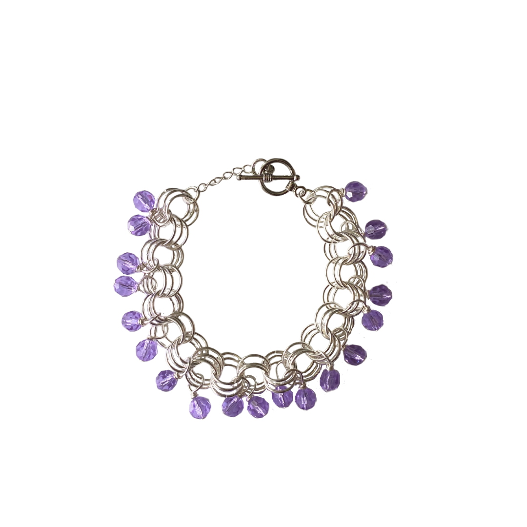 The Donna Bracelet in Violet featuring violet Czech glass beads and gold/silver-plated brass links with a toggle clasp.