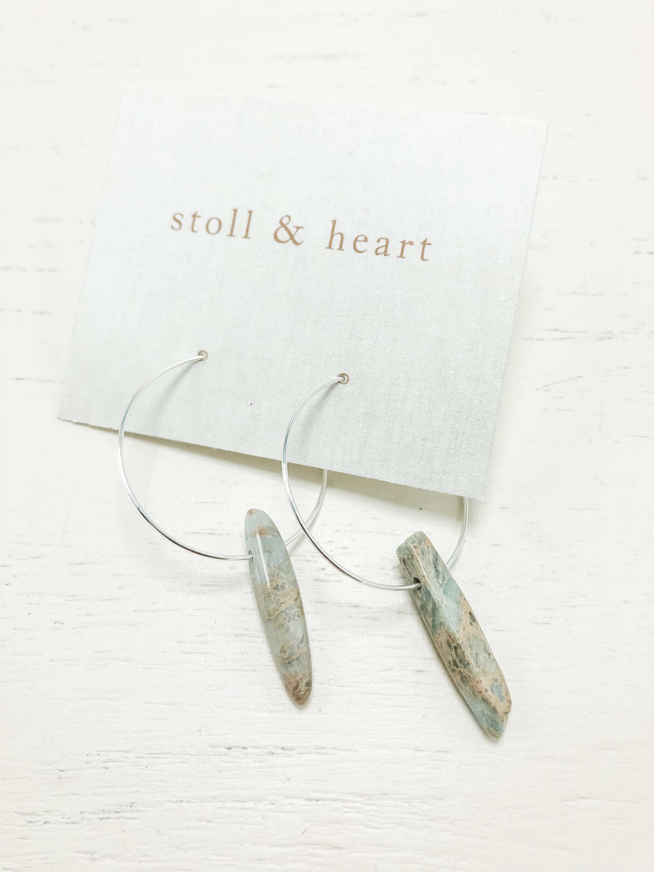 Elegant gold plated hoop earrings featuring blue jasper stones, measuring 2 inches in length.