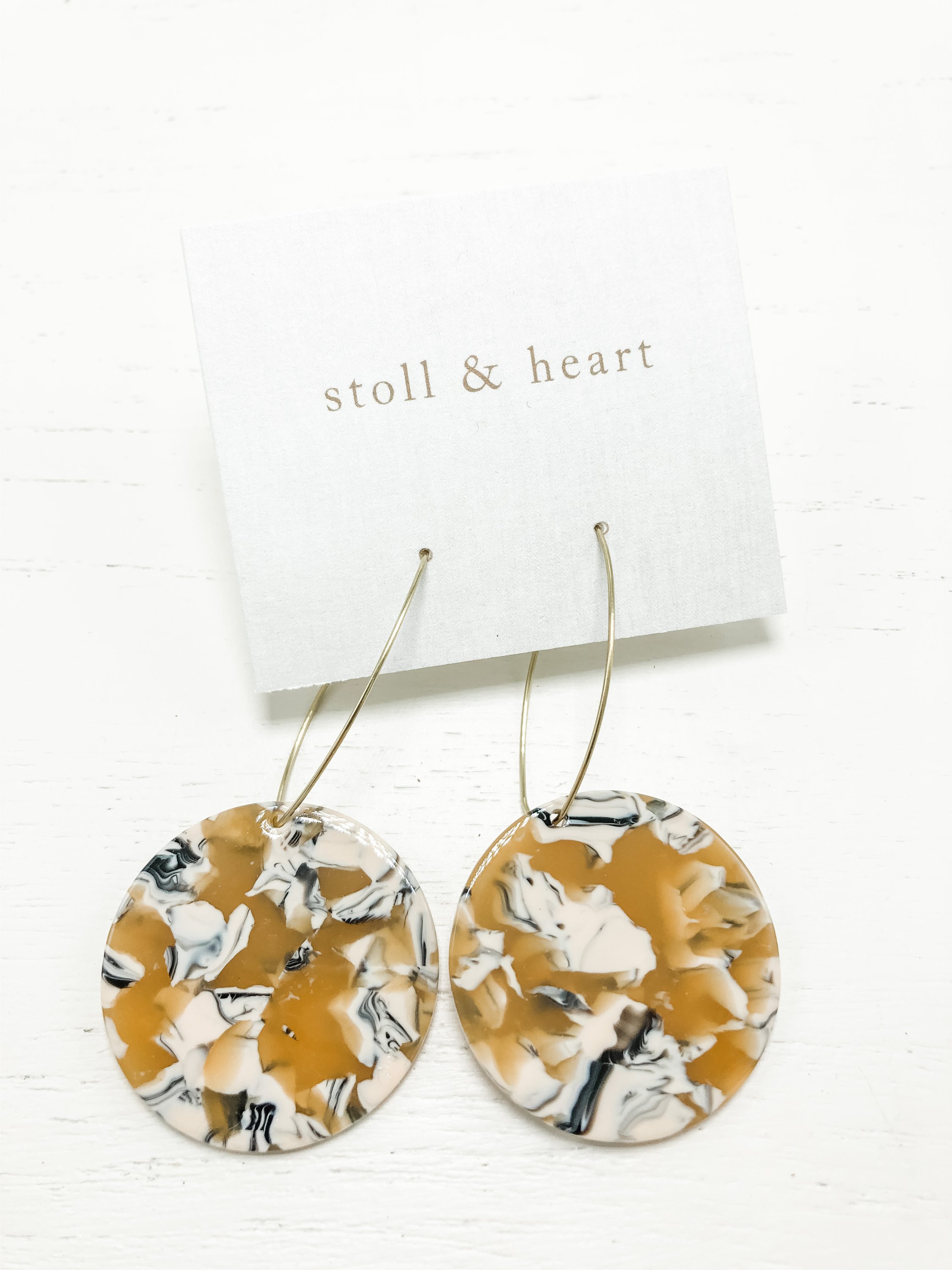 Stylish Maddy Roundies Mustard earrings featuring brass hoops with tortoise resin details in mustard, beige, and black colors.