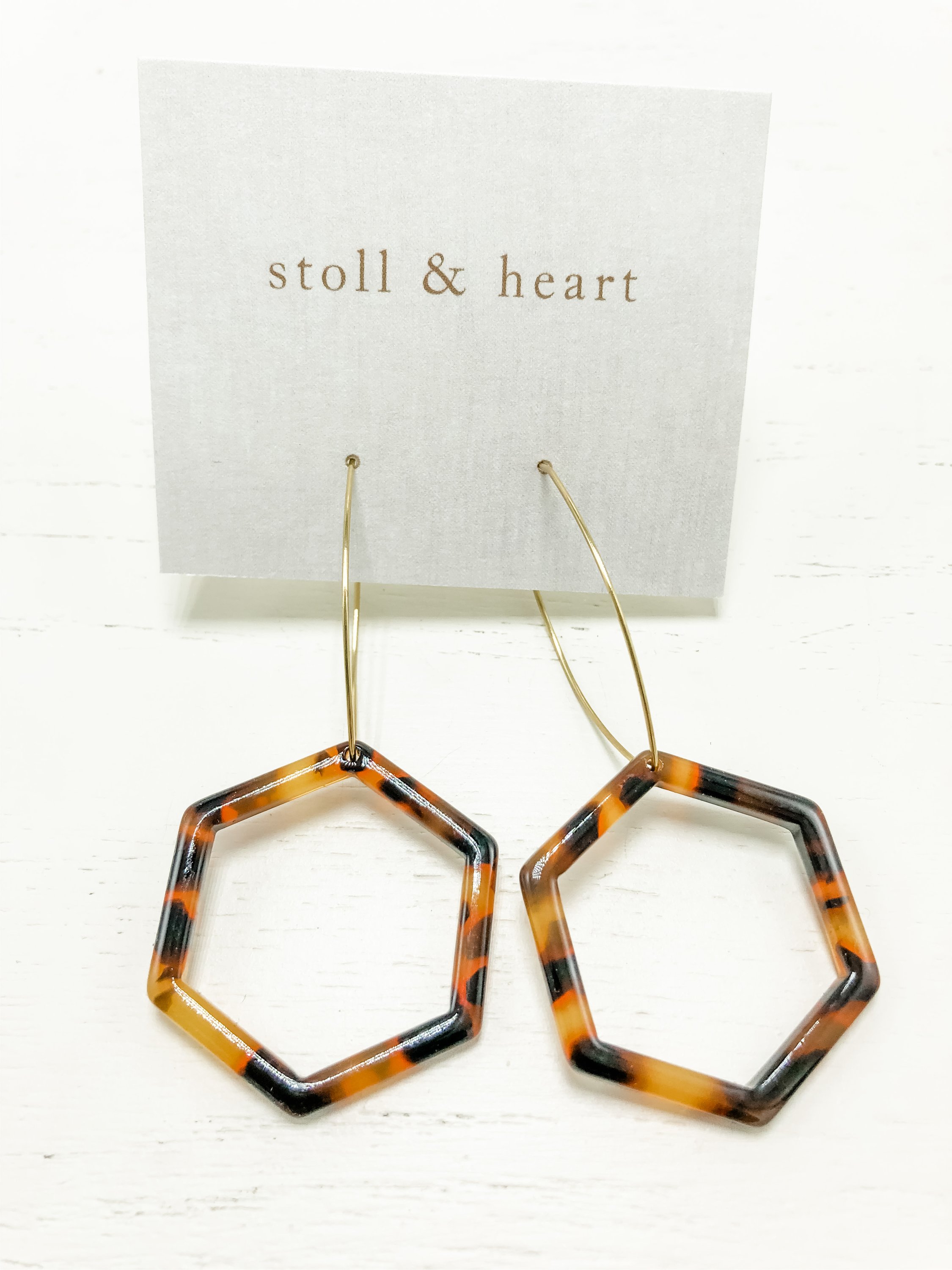 The Mae Dark Tortoise earrings featuring brass hoops and dark tortoise shell resin detail, elegantly displayed.