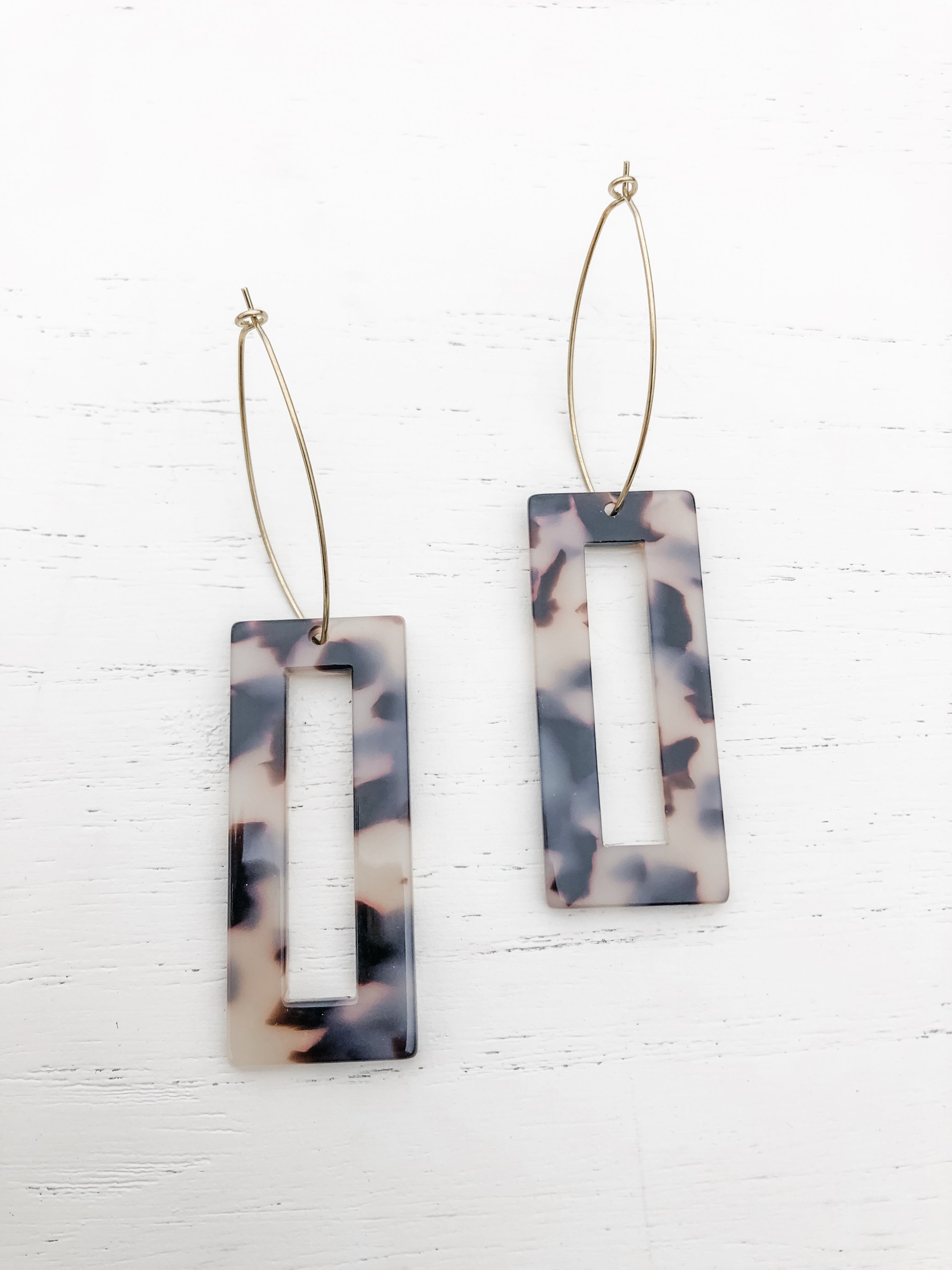 The Marissa Grey Tortoise earrings featuring brass hoops and grey tortoise shell resin detail, elegantly displayed.