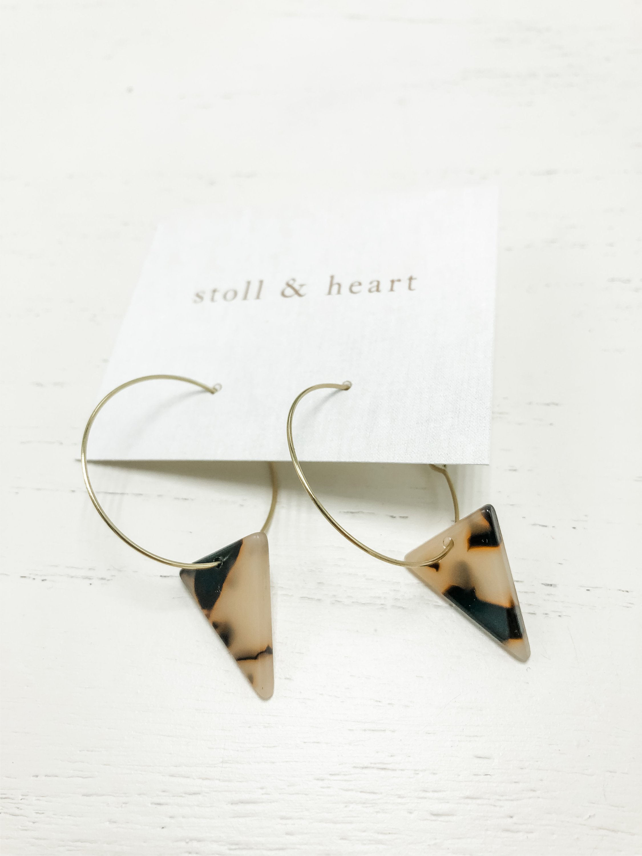 The Marley Light Tortoise Triangle earrings featuring brass hoops and light tortoise shell resin detail, measuring approximately 2 inches in length.