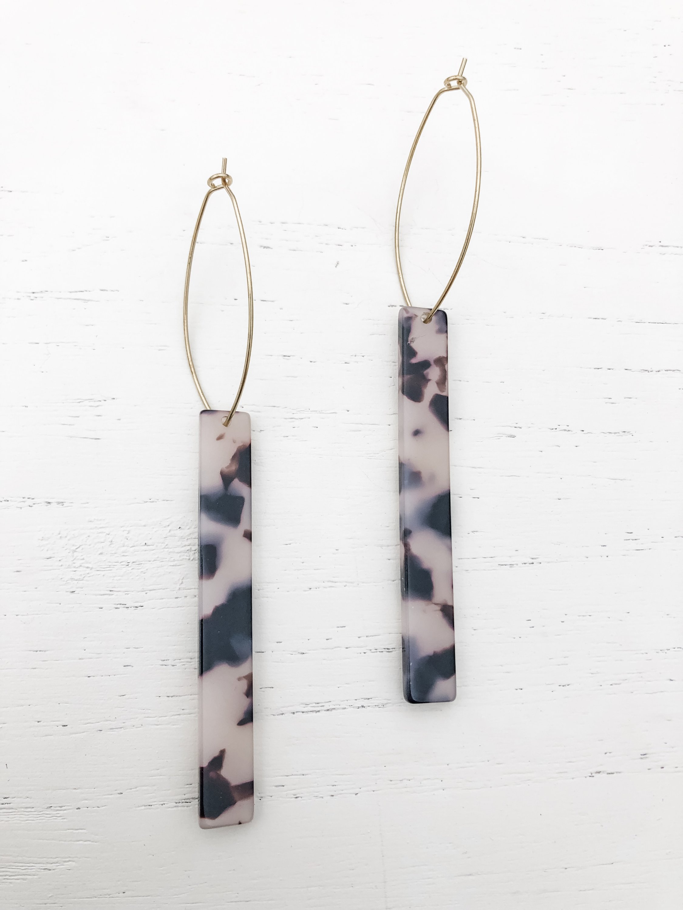 The Melissa Tall Grey Tortoise earrings featuring brass hoops and grey tortoise shell resin detail, elegantly displayed.