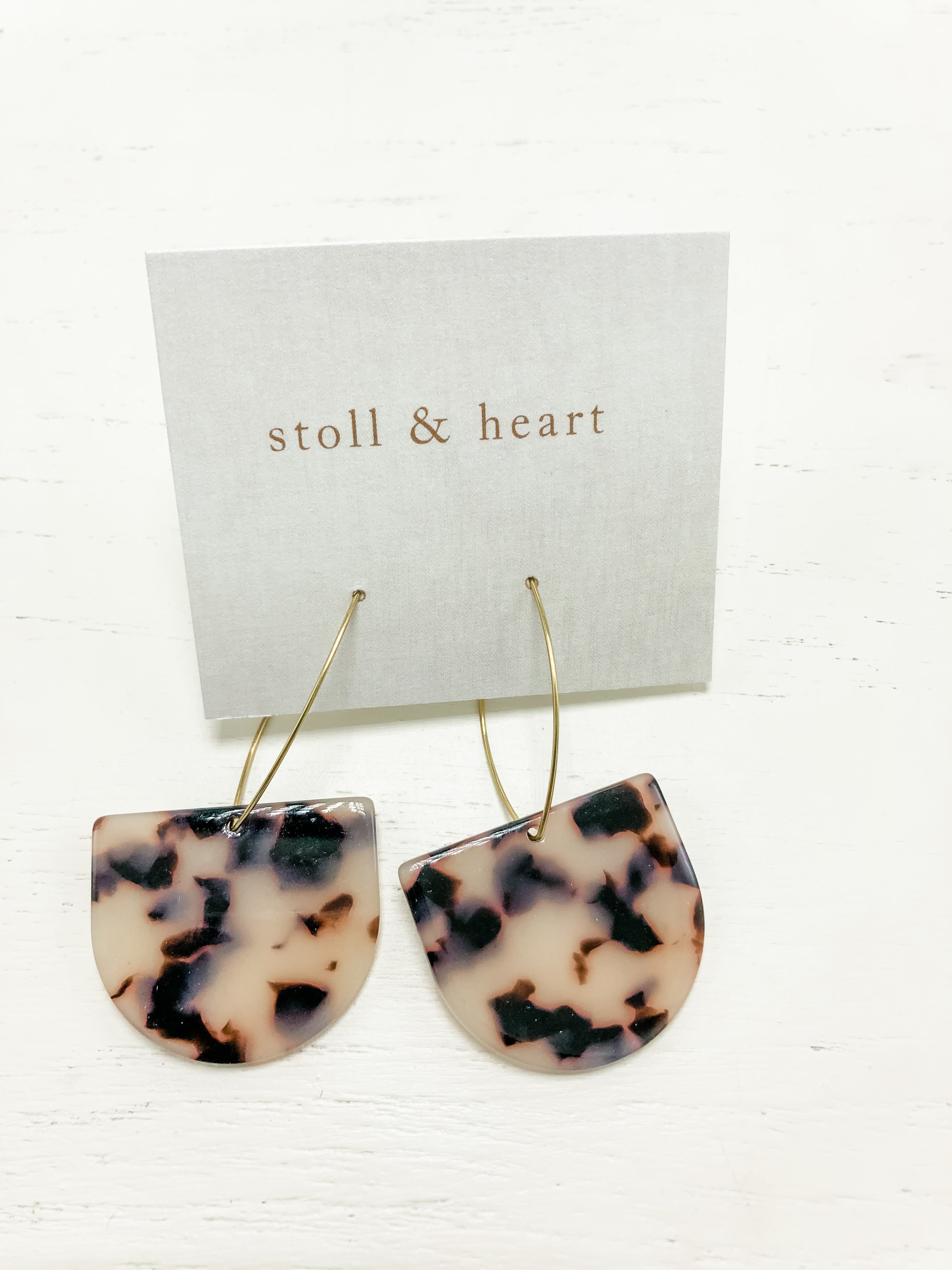 Stylish brass hoop earrings with grey tortoise shell resin detail, measuring 2-7/8 inches in length.