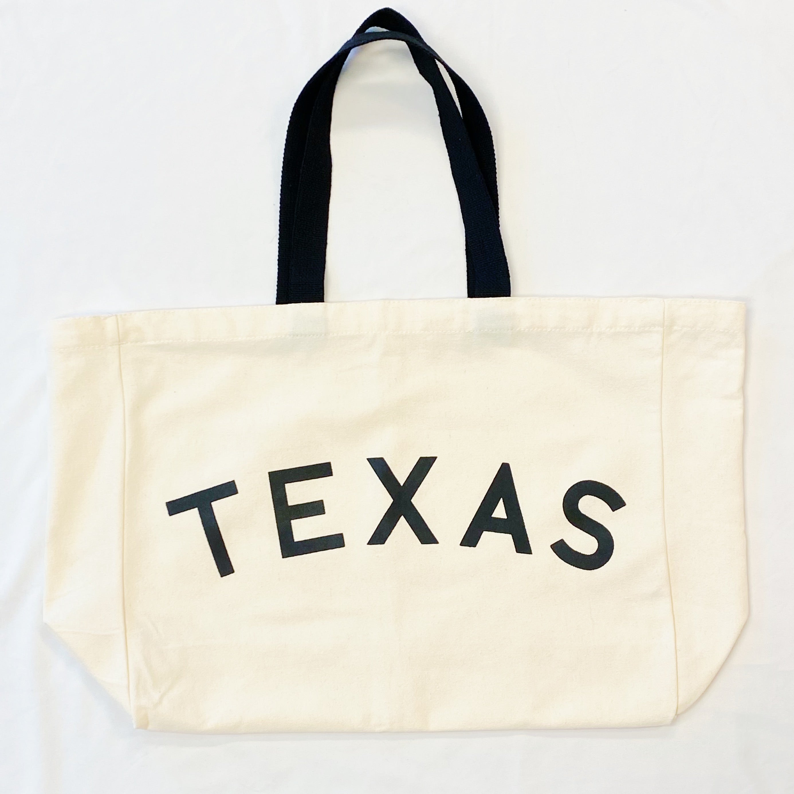 The State On My Mind Canvas Tote featuring a stylish state name print, spacious interior, and eco-friendly design.