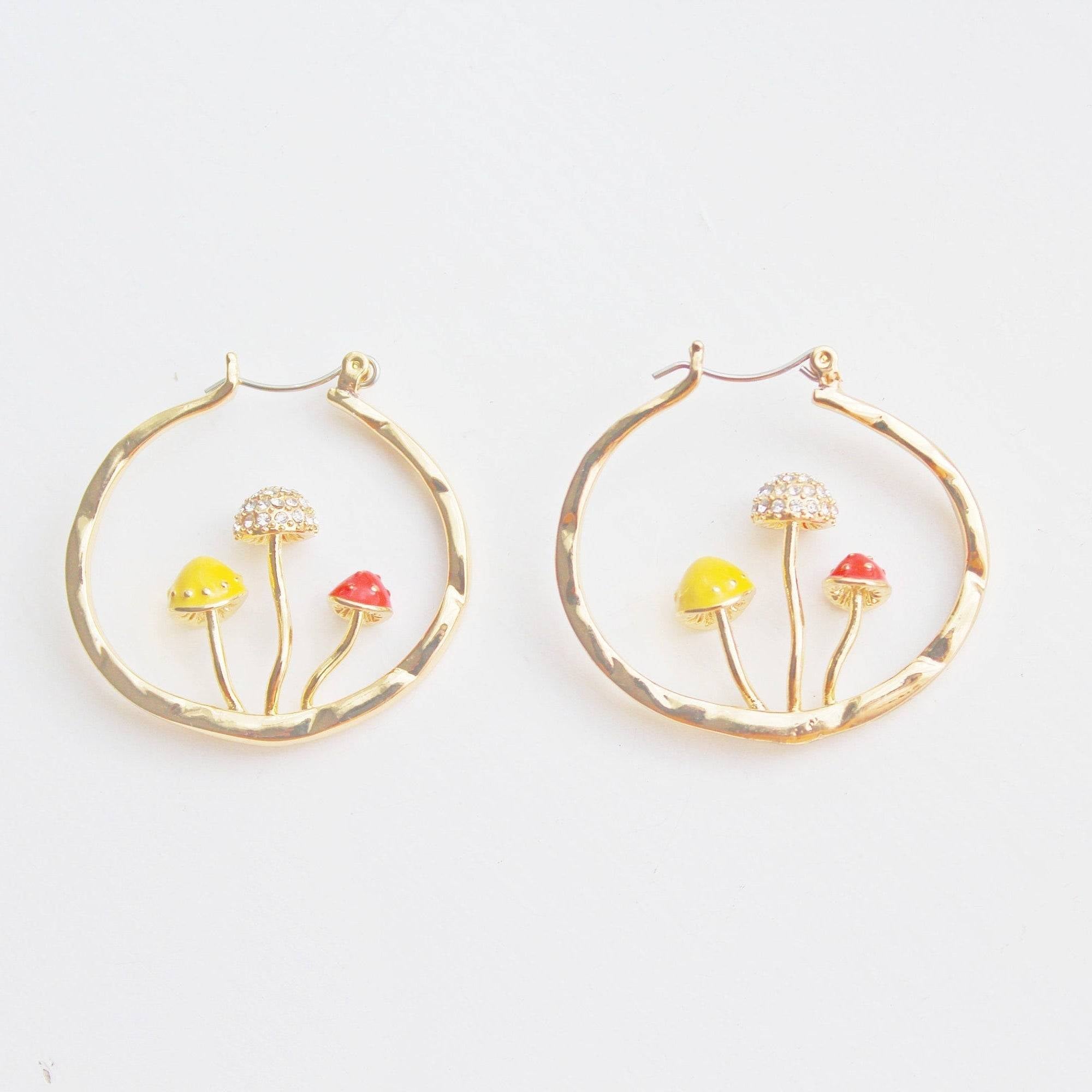 Three handmade gold hoop earrings featuring red fly agaric mushrooms, symbolizing good luck, with a gold plated bronze finish.