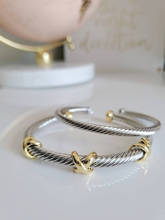 Three X Cable Cuff Bracelet featuring 18K gold filled details and stainless steel material, showcasing a unique three X pattern.