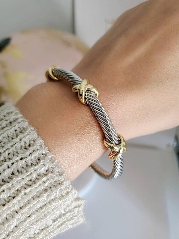 Three X Cable Cuff Bracelet featuring 18K gold filled details and stainless steel material, showcasing a unique three X pattern.