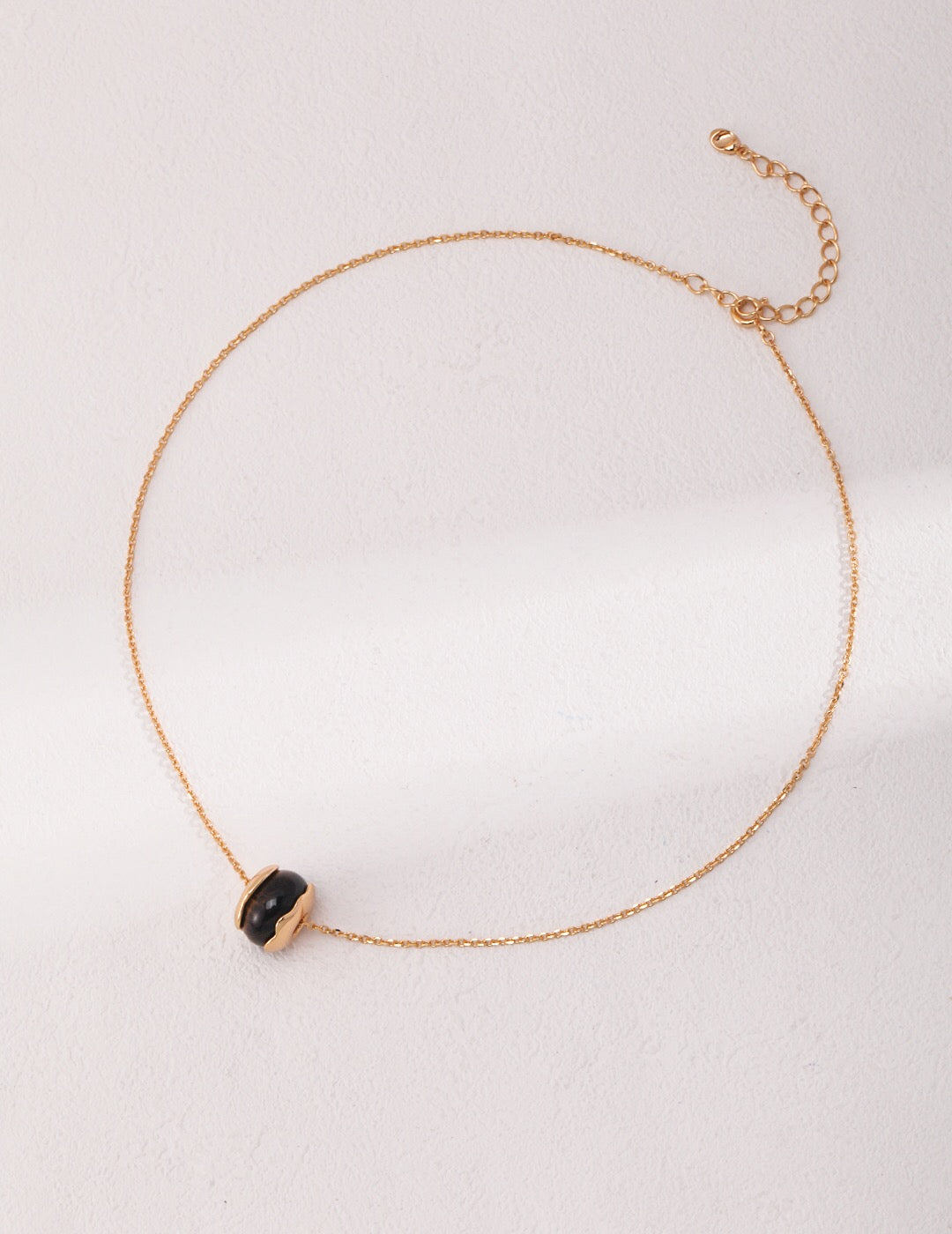 A beautiful handmade Tiger Eye Stone Necklace featuring a heart pendant, gold vermeil accents, and a delicate chain.