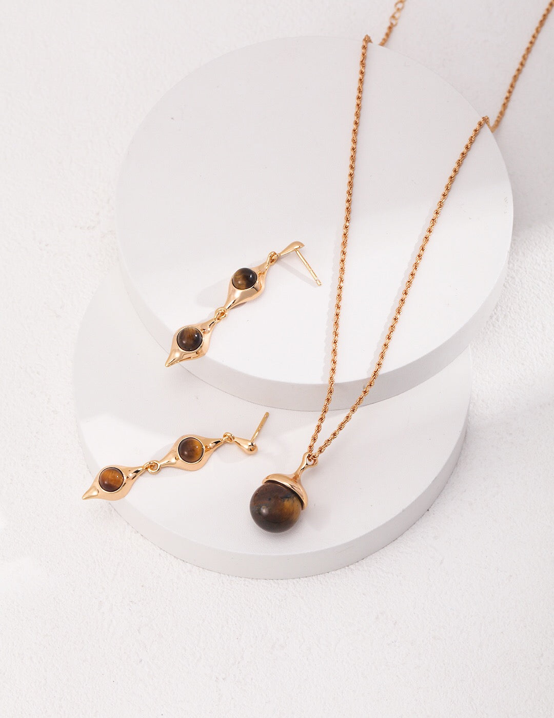 A beautiful Tiger Eye's Ball Necklace featuring gray shell beads and a tiger eye stone, elegantly designed with gold vermeil accents.