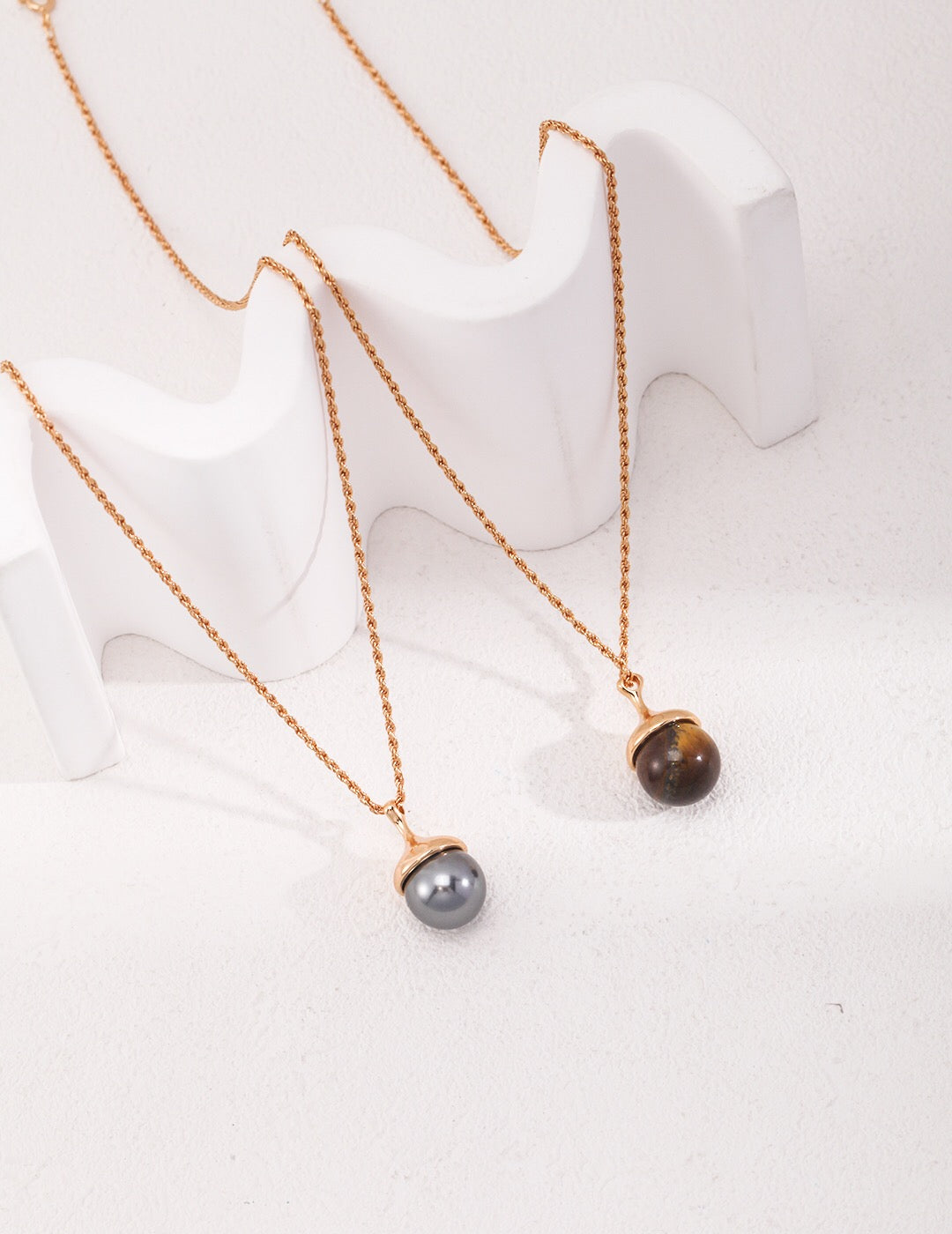 A beautiful Tiger Eye's Ball Necklace featuring gray shell beads and a tiger eye stone, elegantly designed with gold vermeil accents.