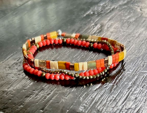 Tila Set Harvest Wheat & Orange Stretchy Tila Bead Bracelet featuring vibrant peachy-orange and wheat colors, wrapped around a wrist.