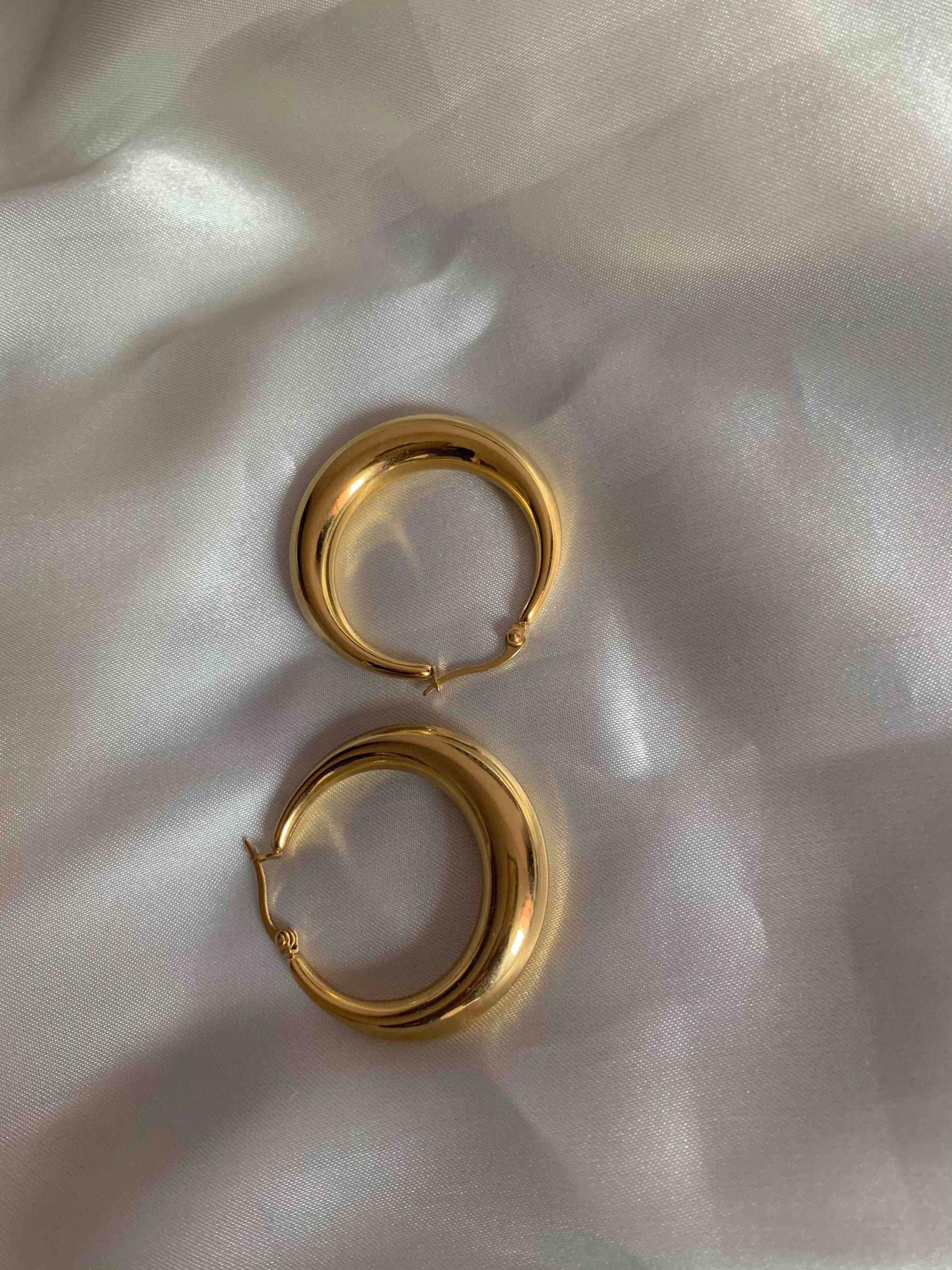 Timothy Gold Hoops earrings in small and large sizes, showcasing a thick chunky design with a polished finish.