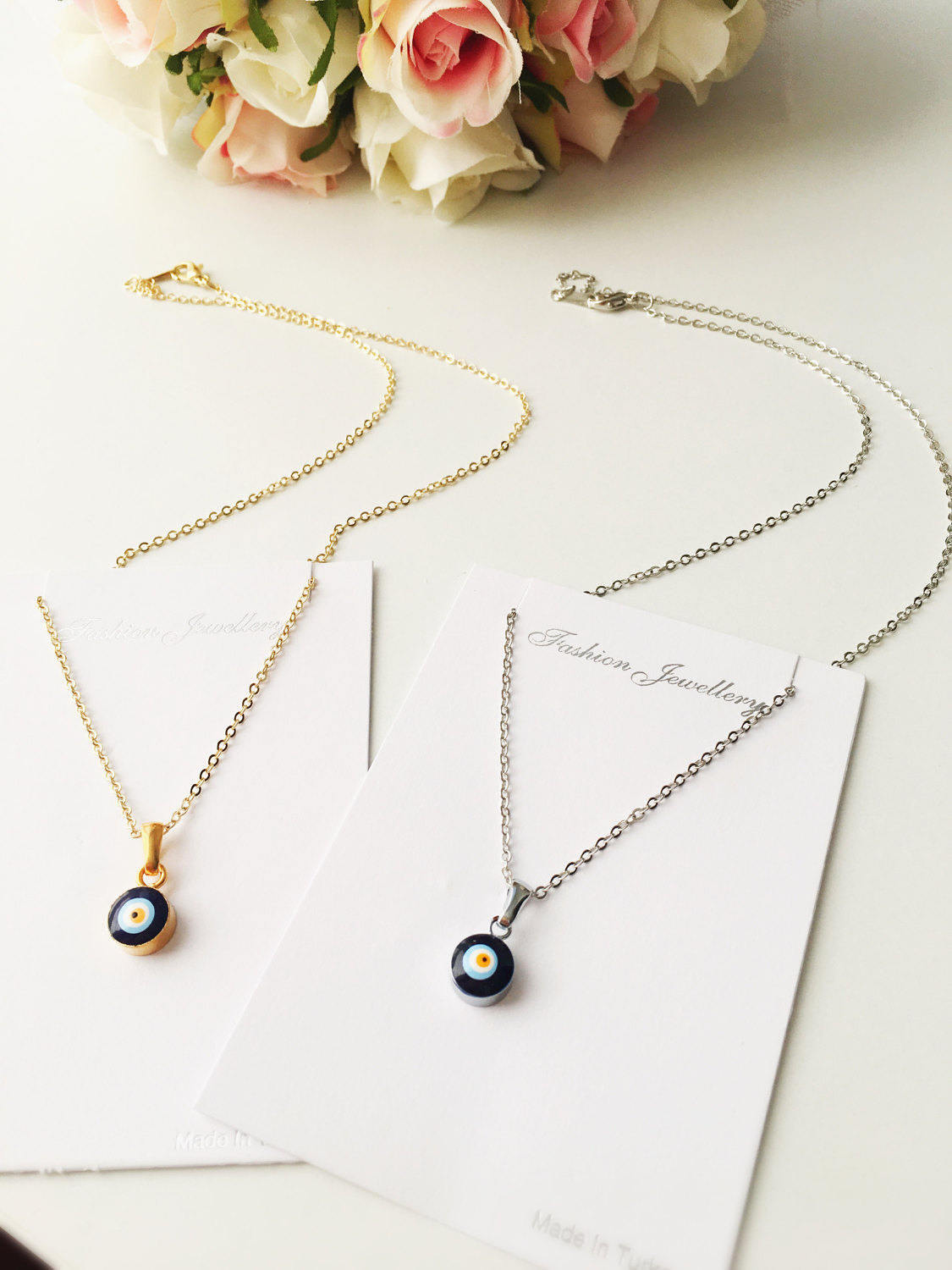 A delicate Tiny Evil Eye Necklace featuring a blue evil eye bead on a gold chain, symbolizing protection and style.