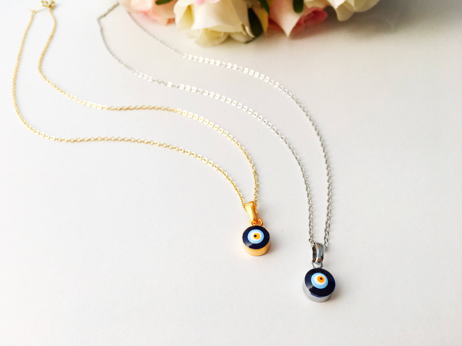 A delicate Tiny Evil Eye Necklace featuring a blue evil eye bead on a gold chain, symbolizing protection and style.