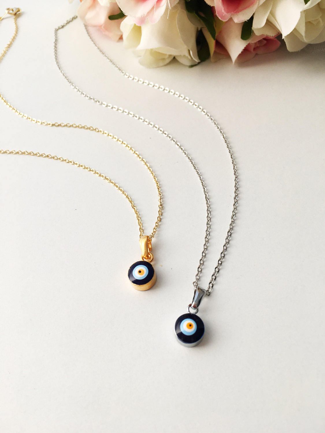 A delicate Tiny Evil Eye Necklace featuring a blue evil eye bead on a gold chain, symbolizing protection and style.