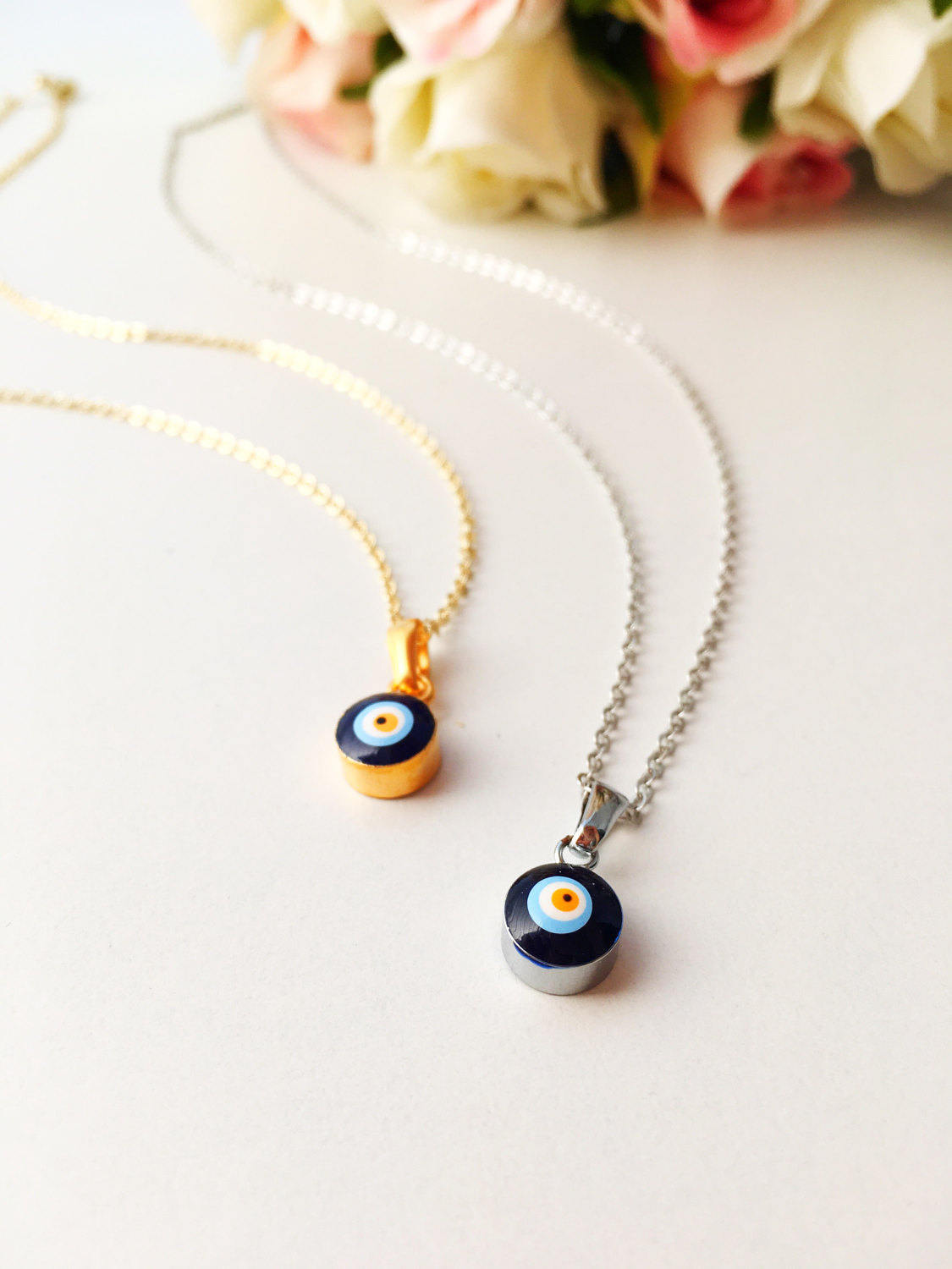 A delicate Tiny Evil Eye Necklace featuring a blue evil eye bead on a gold chain, symbolizing protection and style.